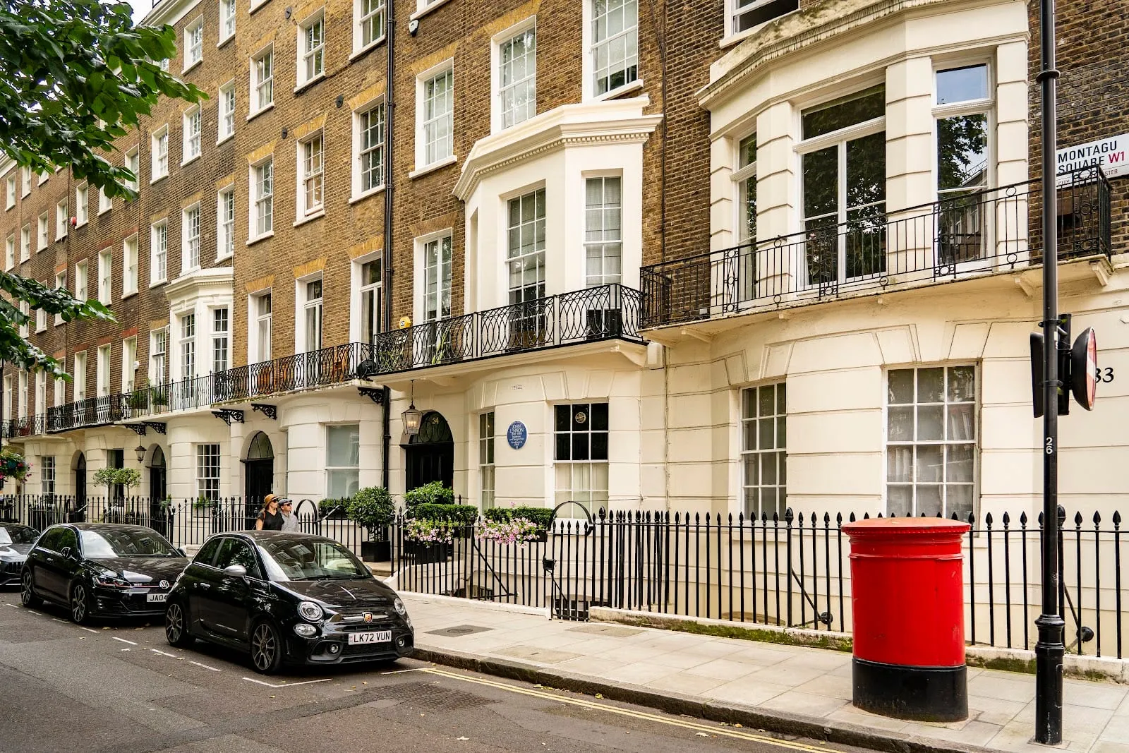 The cream-stucco terrace of Montagu Square, with a blue plaque to John Lennon beside the door of number 34 and a red pillar box on the pavement