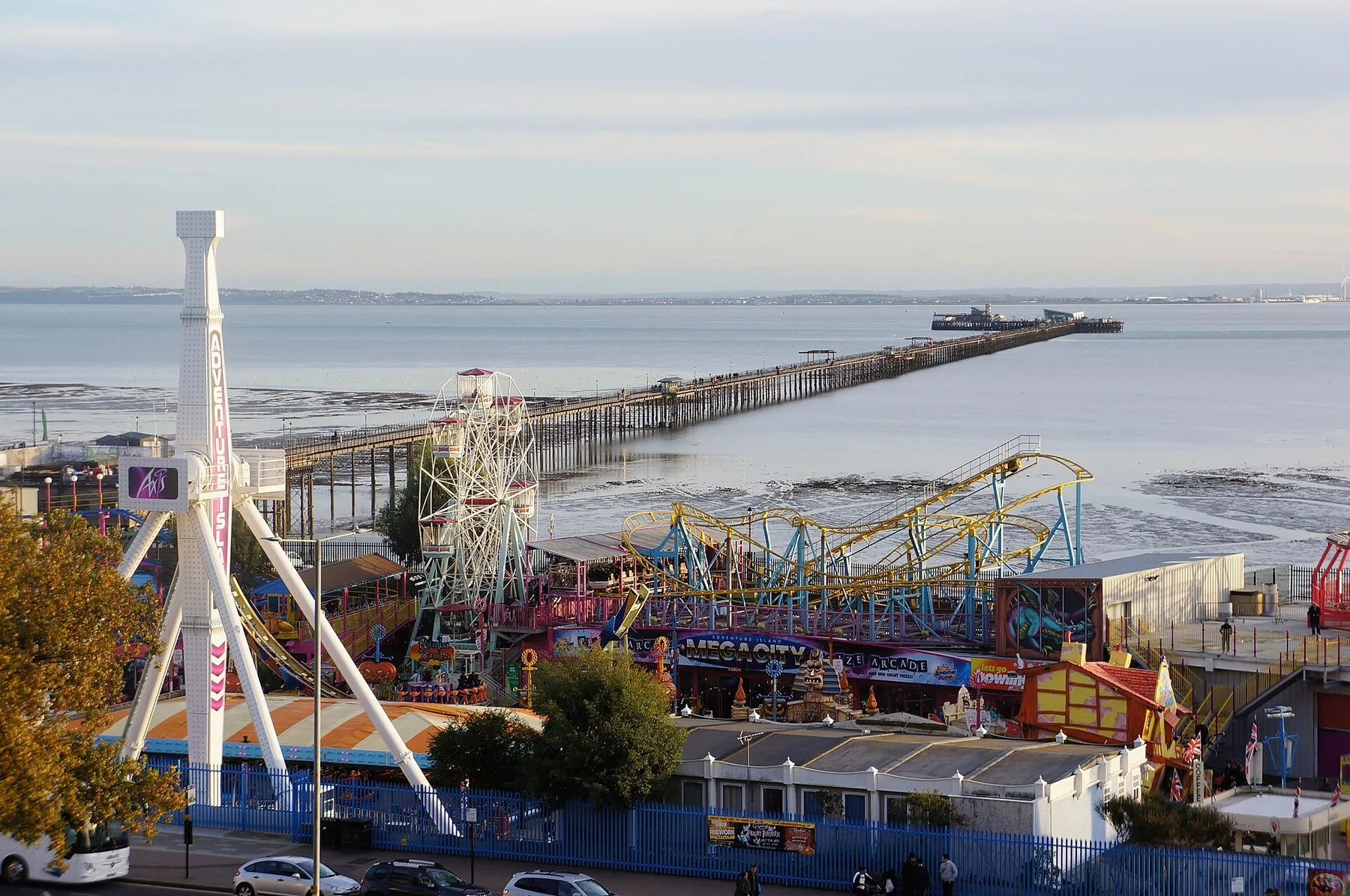 Adventure Island on Southend seafront, coasters and a big wheel in the foreground and Southend Pier running out into the Thames estuary behind