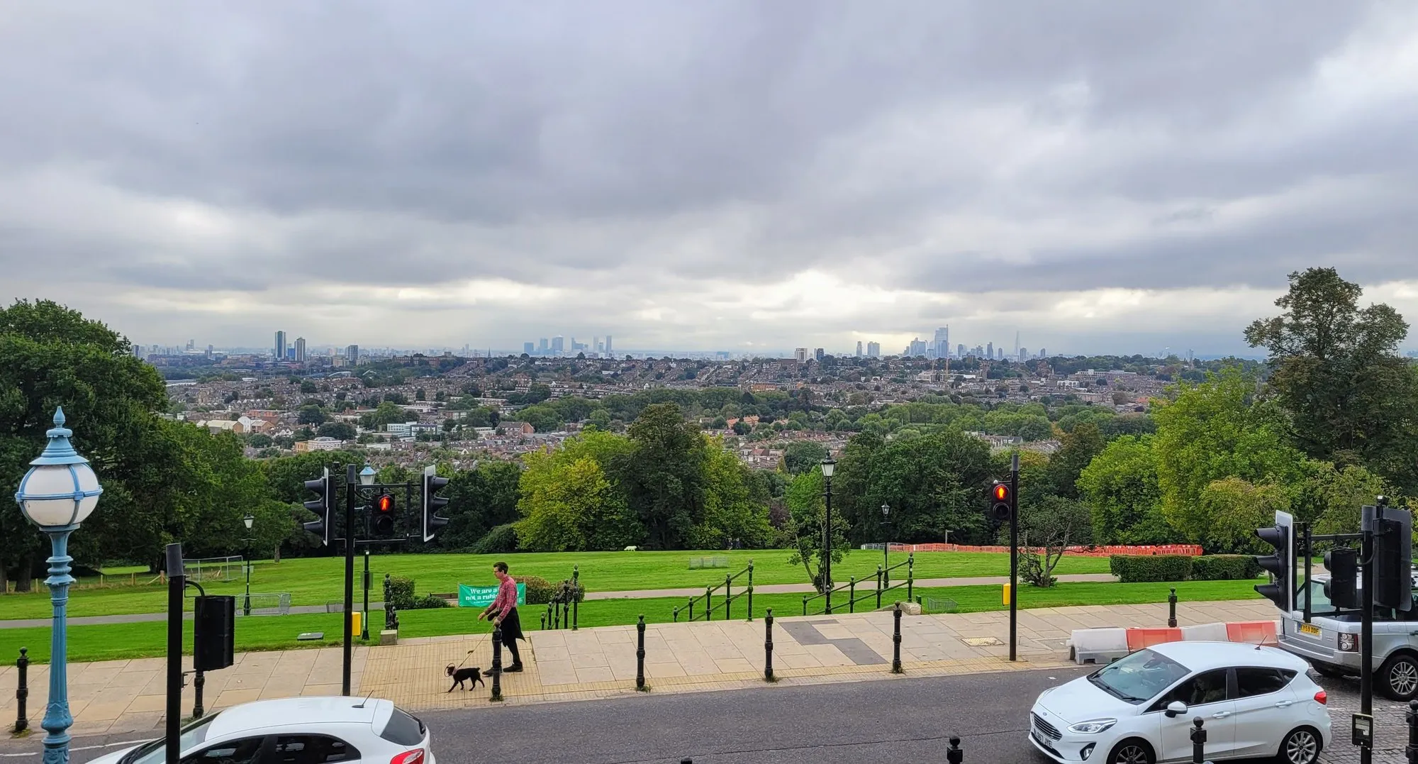 The London skyline seen from Alexandra Palace terrace, with Canary Wharf and the City visible in the distance under a grey sky