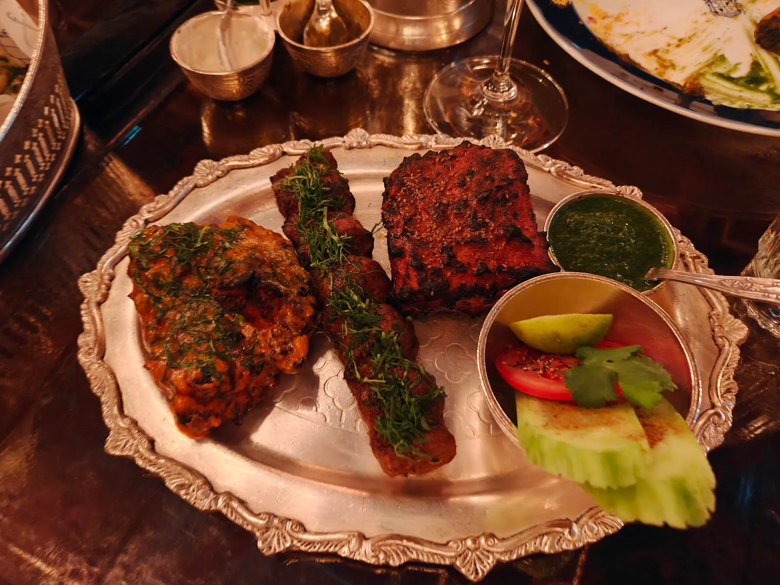 A silver platter of tandoori meats, seekh kebabs, green chutney and salad at Ambassadors Clubhouse