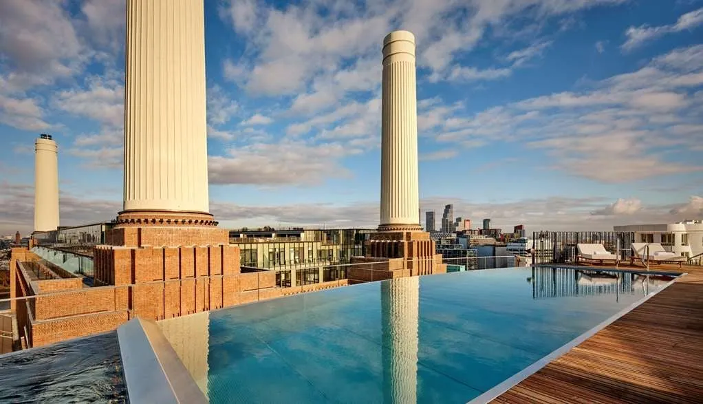 The rooftop infinity pool at art'otel London Battersea Power Station, with the power station's chimneys beyond