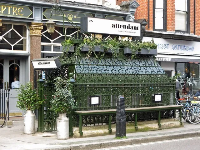 The ornate Victorian cast-iron entrance to a former underground gents' toilet on Foley Street, Fitzrovia, now signed as the Attendant coffee shop