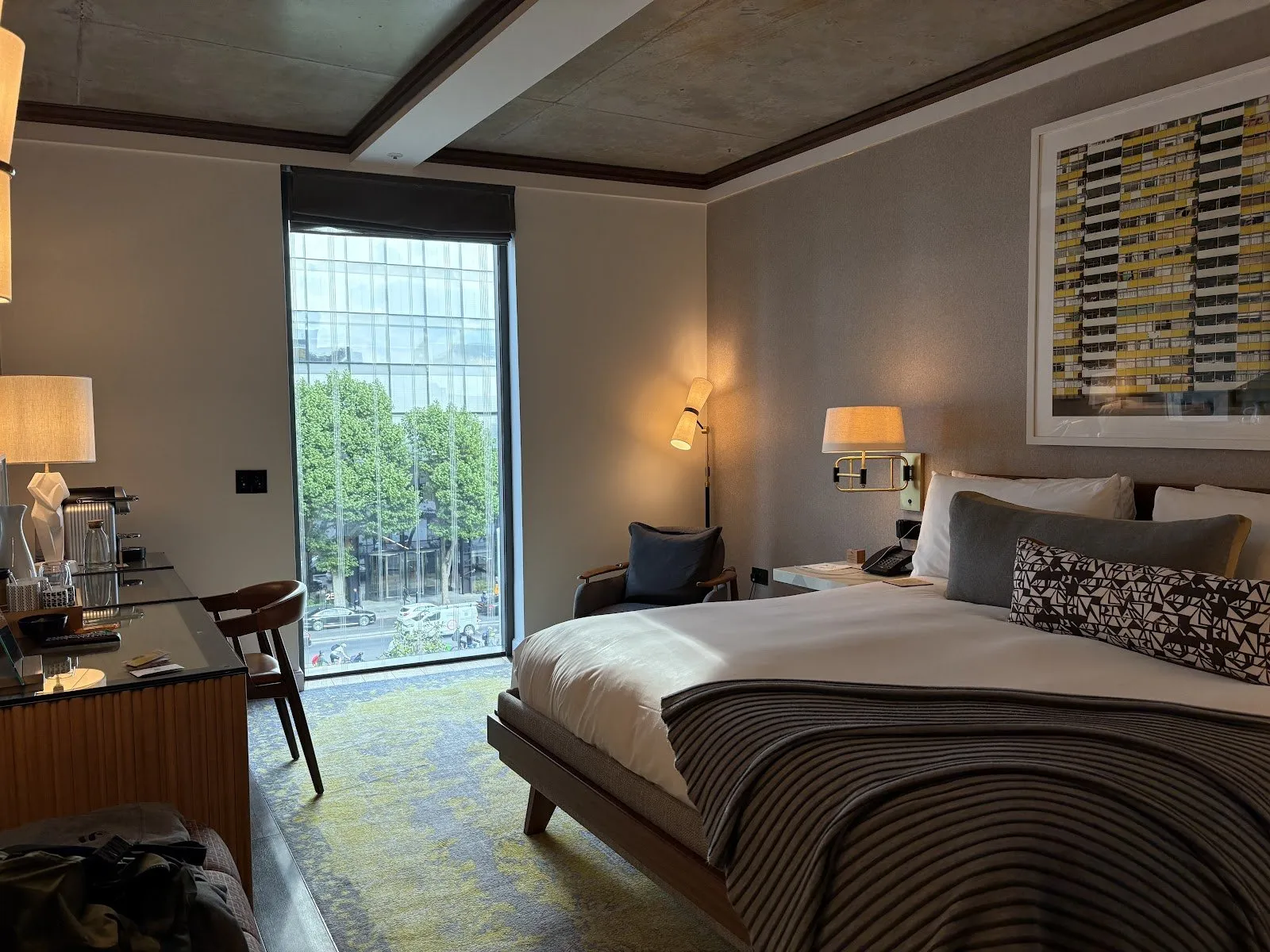 A room at Bankside Hotel with a dark wood floor, a concrete ceiling and a floor-to-ceiling window looking over Blackfriars Road
