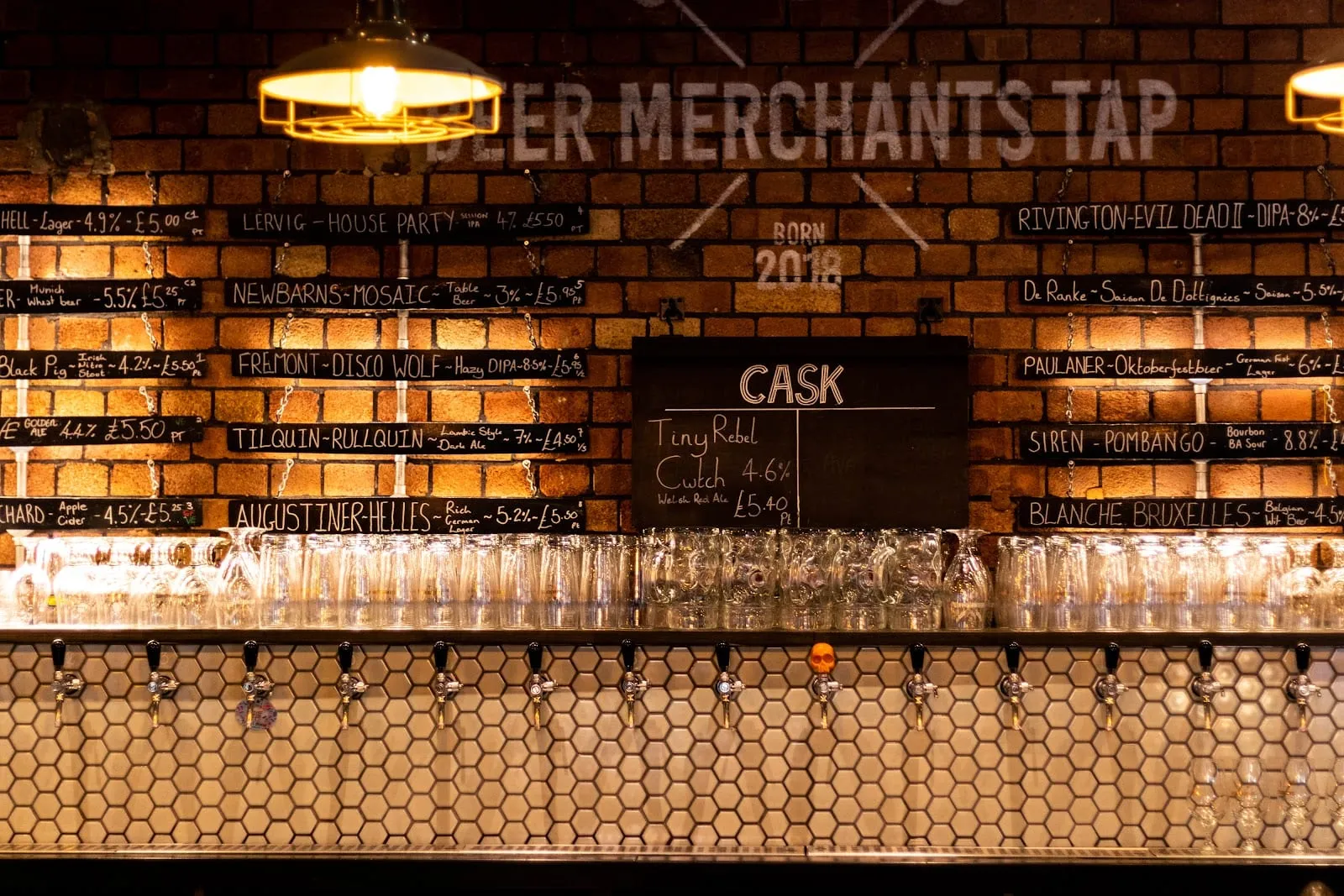 The tap wall at Beer Merchants Tap, stencilled with the pub's name above chalkboards listing beers from Lervig, Newbarns, Fremont and Rivington