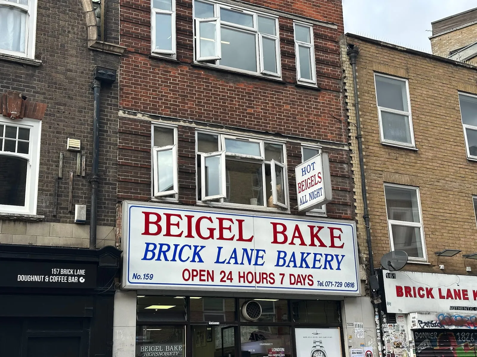 The Beigel Bake shopfront on Brick Lane, its sign reading Brick Lane Bakery, open 24 hours 7 days, with a hot beigels all night sign above