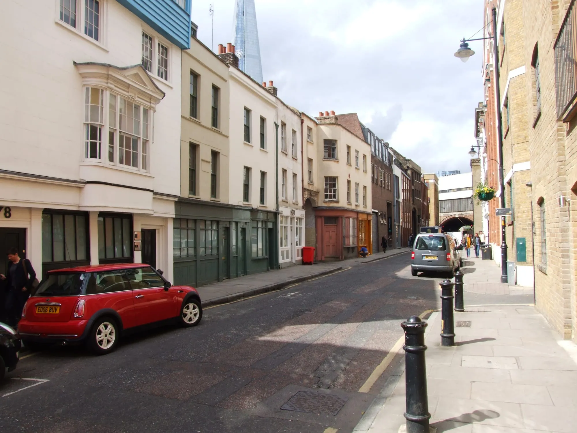 Georgian houses and painted shopfronts on Bermondsey Street with the Shard rising behind