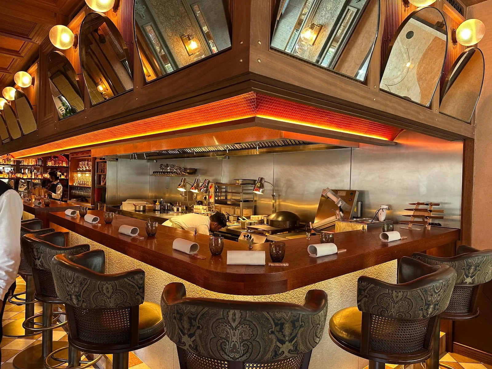 The dining counter at BiBi in Mayfair overlooking the open charcoal grill under brass mirrors