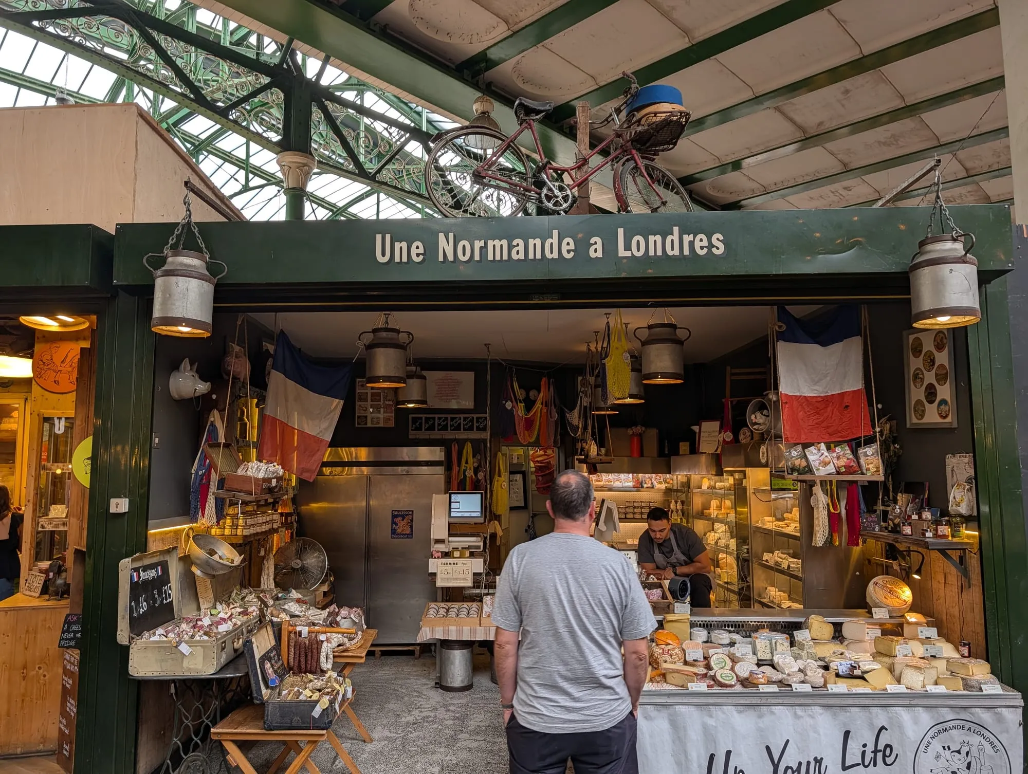 A cheese stall at Borough Market with wheels of cheese stacked behind the counter