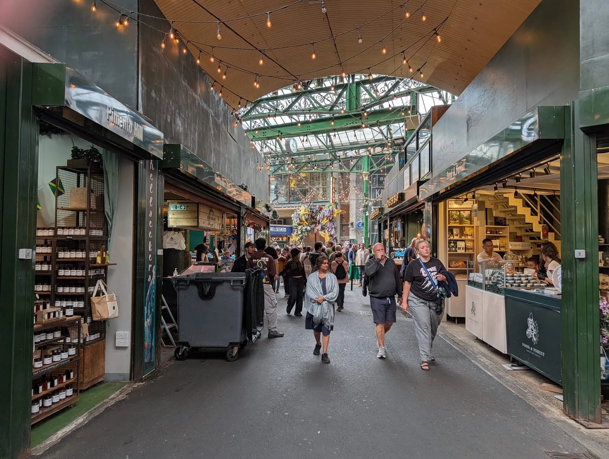 A produce-lined aisle running through Borough Market under its green iron roof