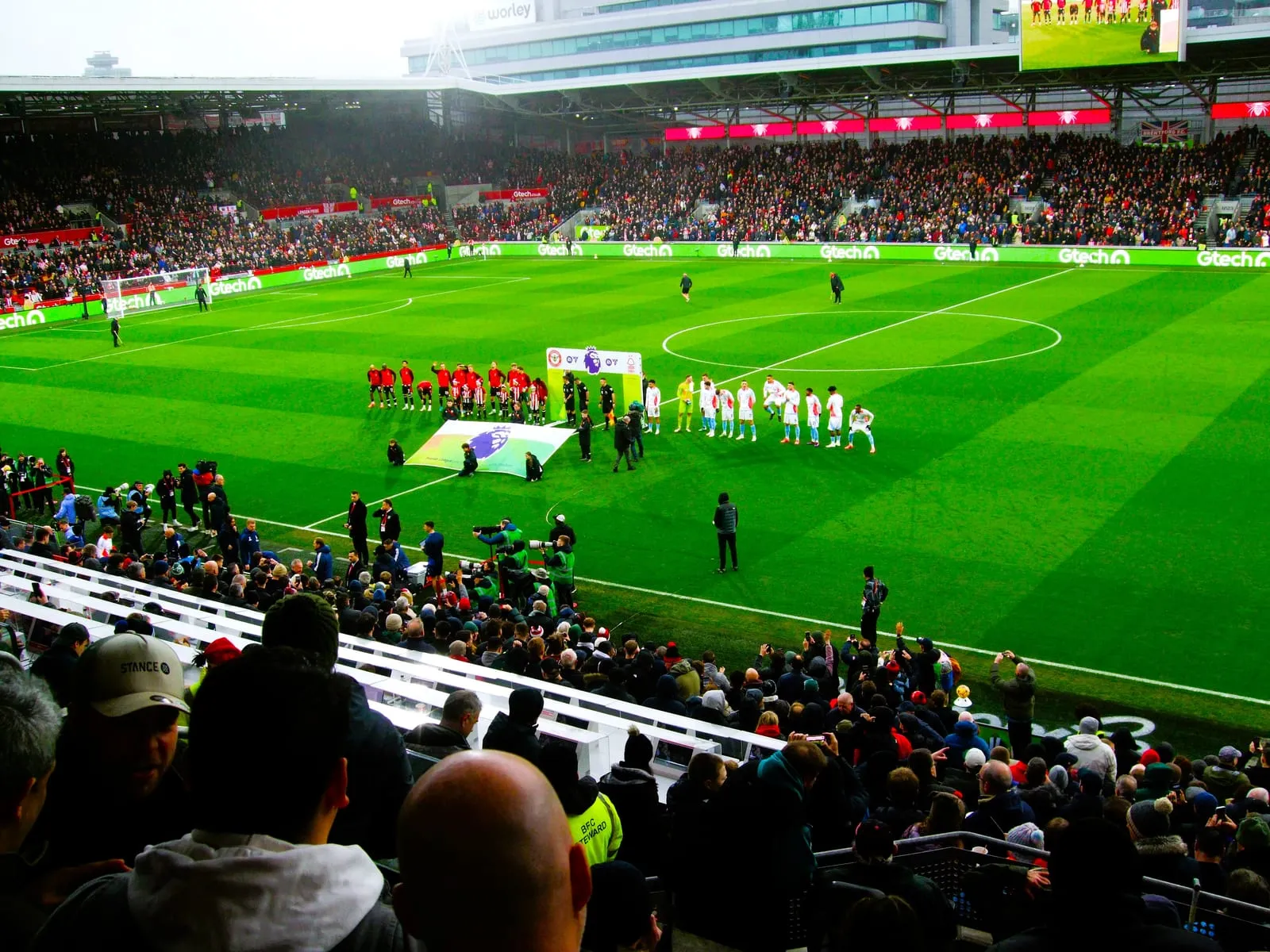 Teams lined up on the pitch at Gtech Community Stadium ahead of a Premier League match