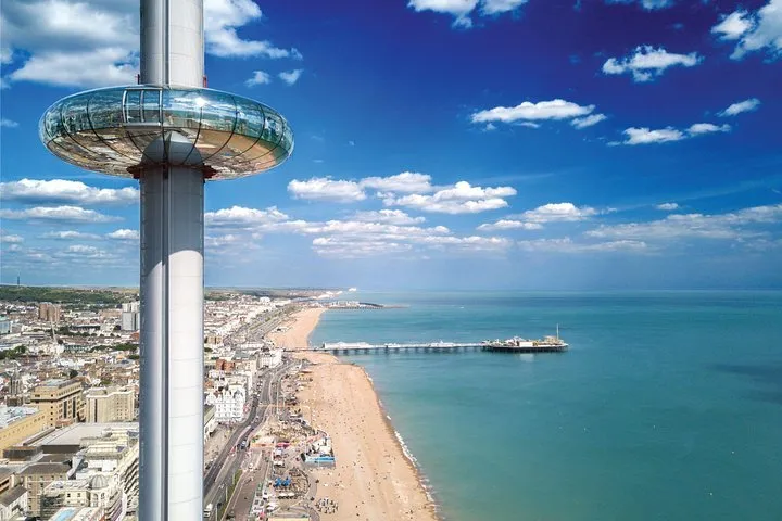 The Brighton i360 tower and observation pod rising above the seafront, with the beach and Brighton Palace Pier below