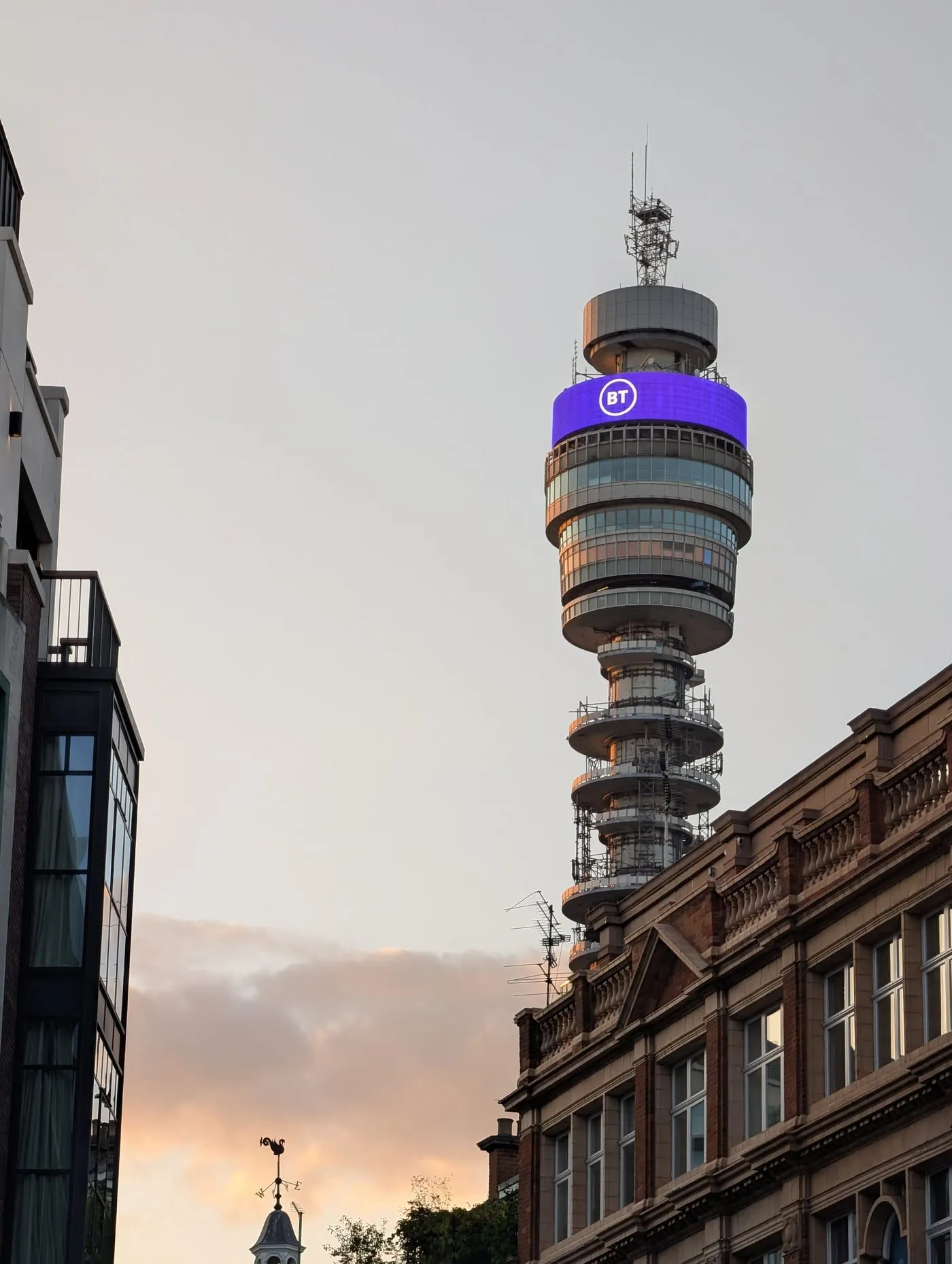 The BT Tower rising above Georgian rooftops in Fitzrovia at dusk