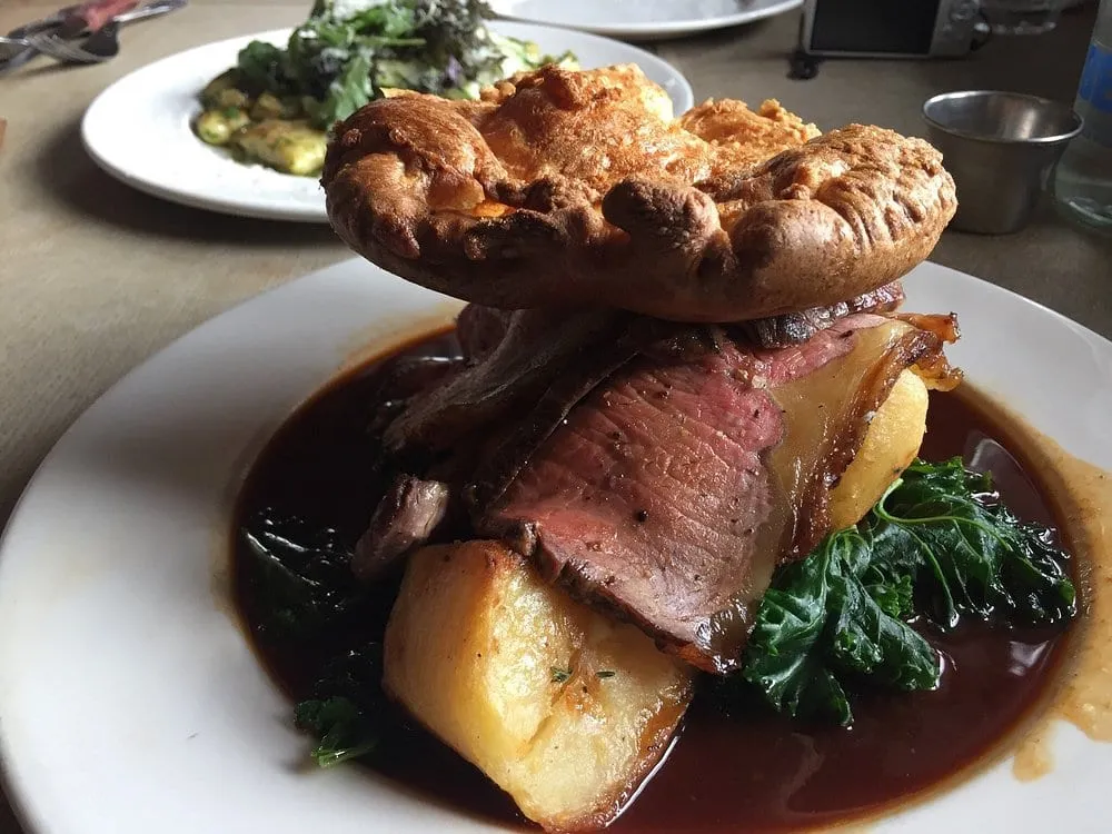 A roast at The Bull and Last: pink beef and roast potatoes in a deep pool of gravy with kale, a large Yorkshire pudding balanced on top