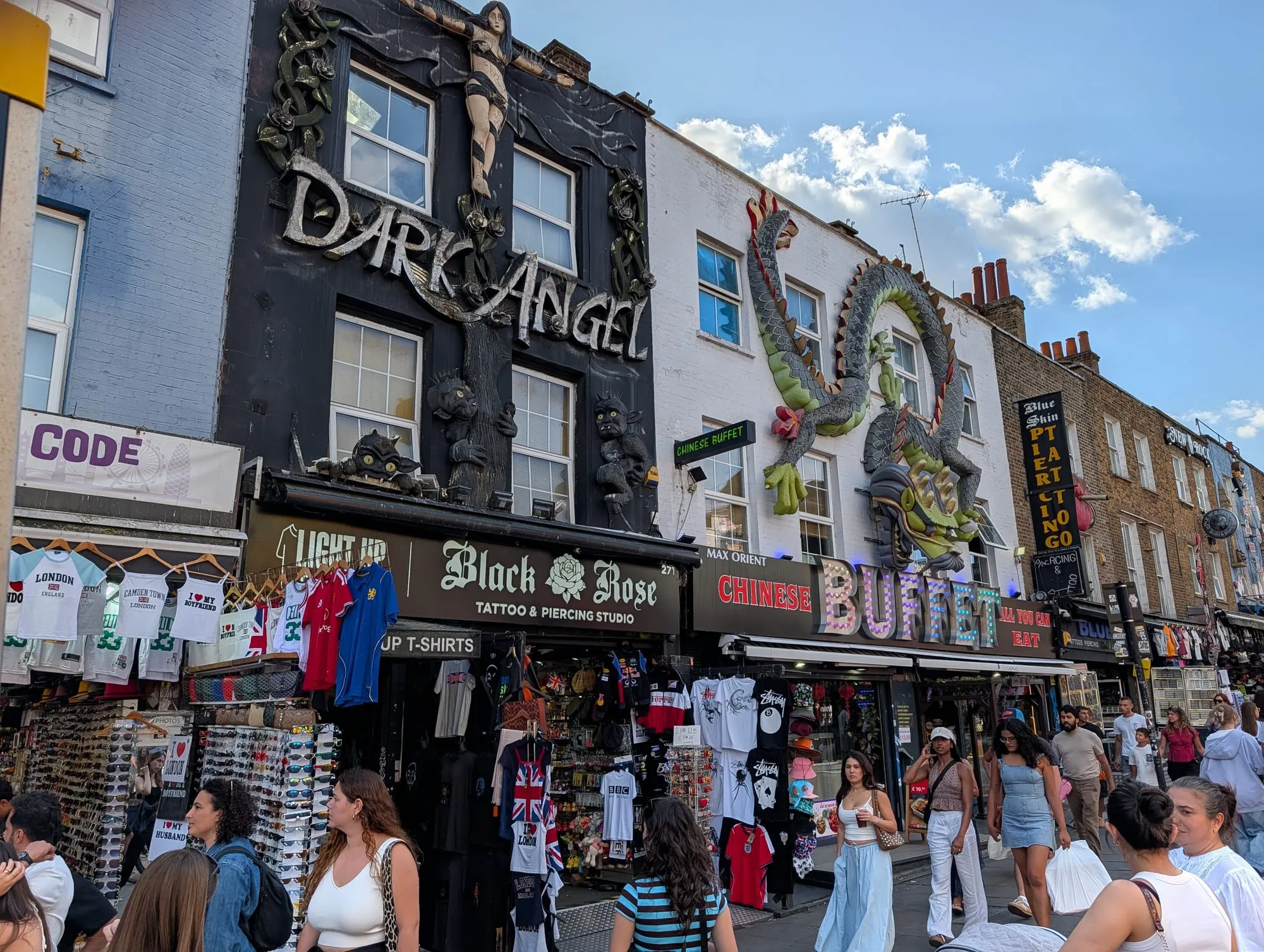 Camden High Street shopfronts with a giant painted dragon and an oversized boot mounted above the shops