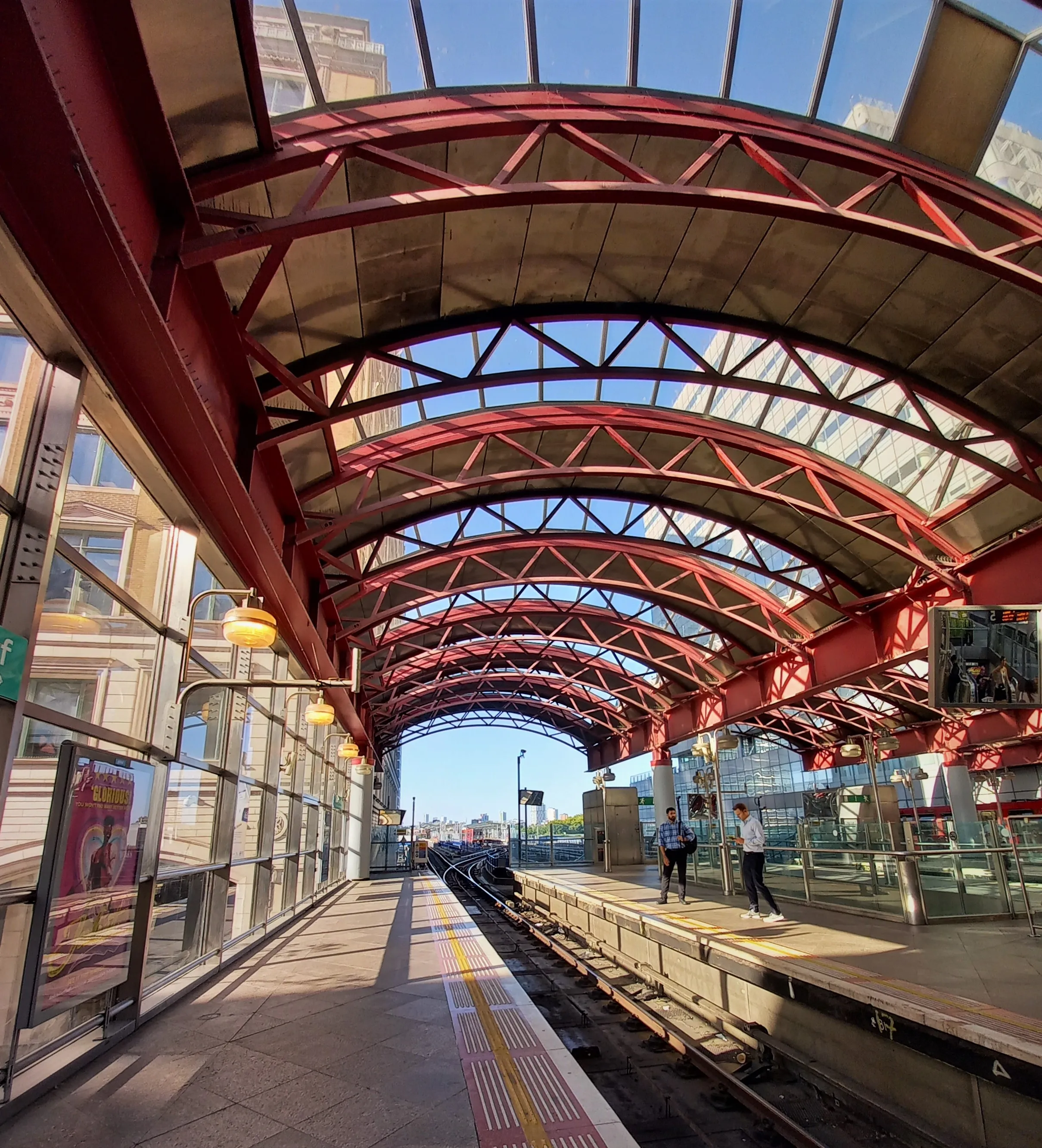 A DLR train beneath the high roof of Canary Wharf station.