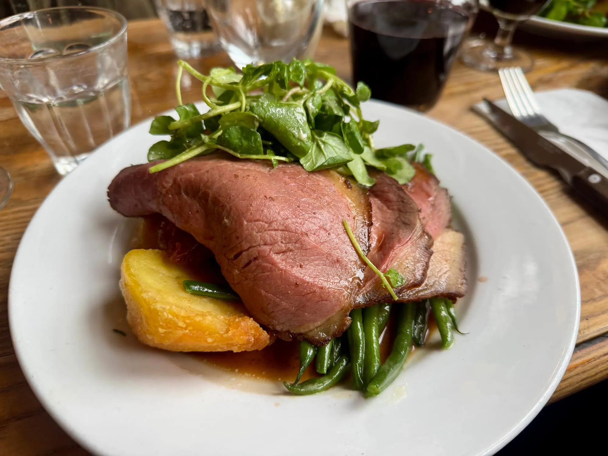 A Sunday roast at the Canton Arms: sliced beef topped with watercress, a roast potato wedge and green beans in gravy