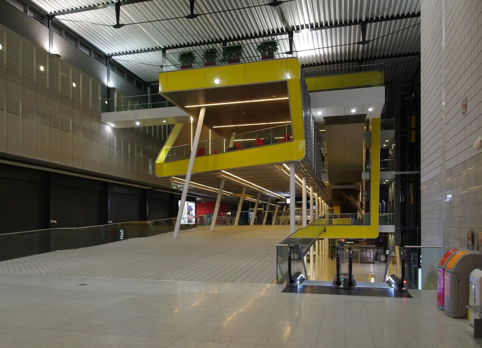 An escalator and mezzanine level inside ExCeL London's boulevard, empty of visitors