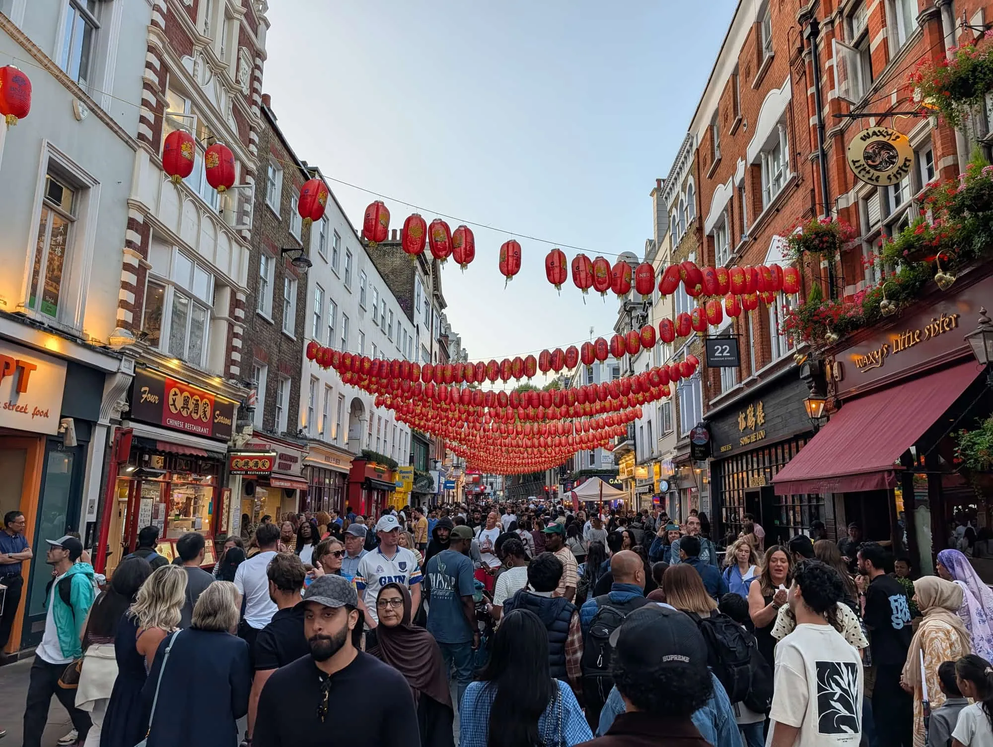 Red lanterns strung above a crowded Gerrard Street in Chinatown