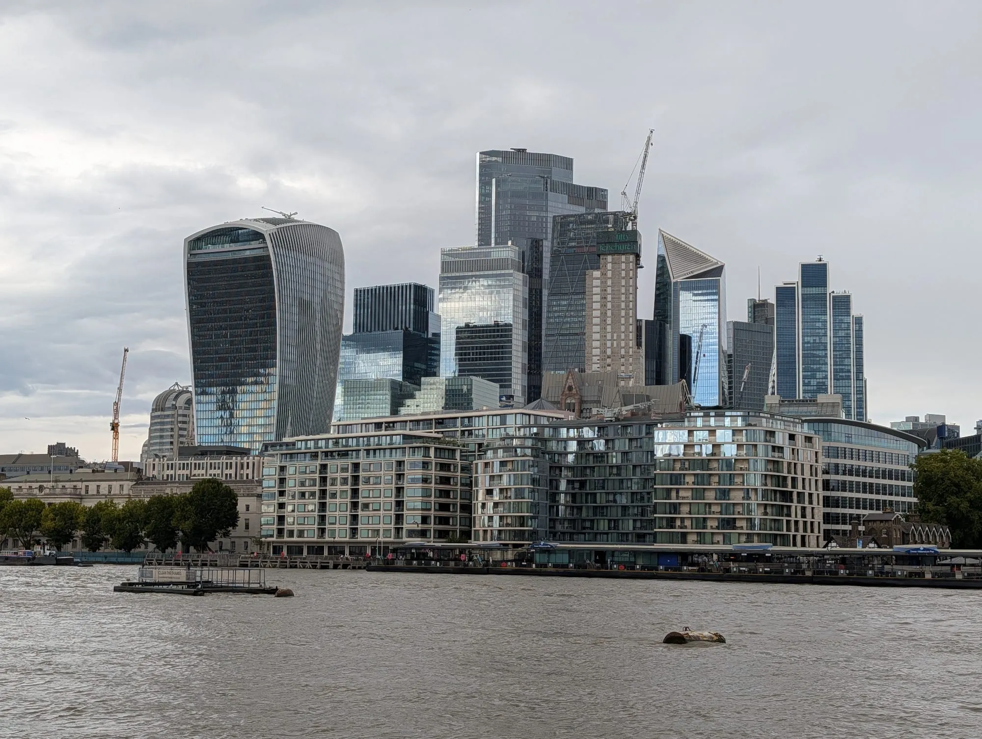 The City's tower cluster seen across the Thames, the Walkie-Talkie and Cheesegrater rising behind riverside flats