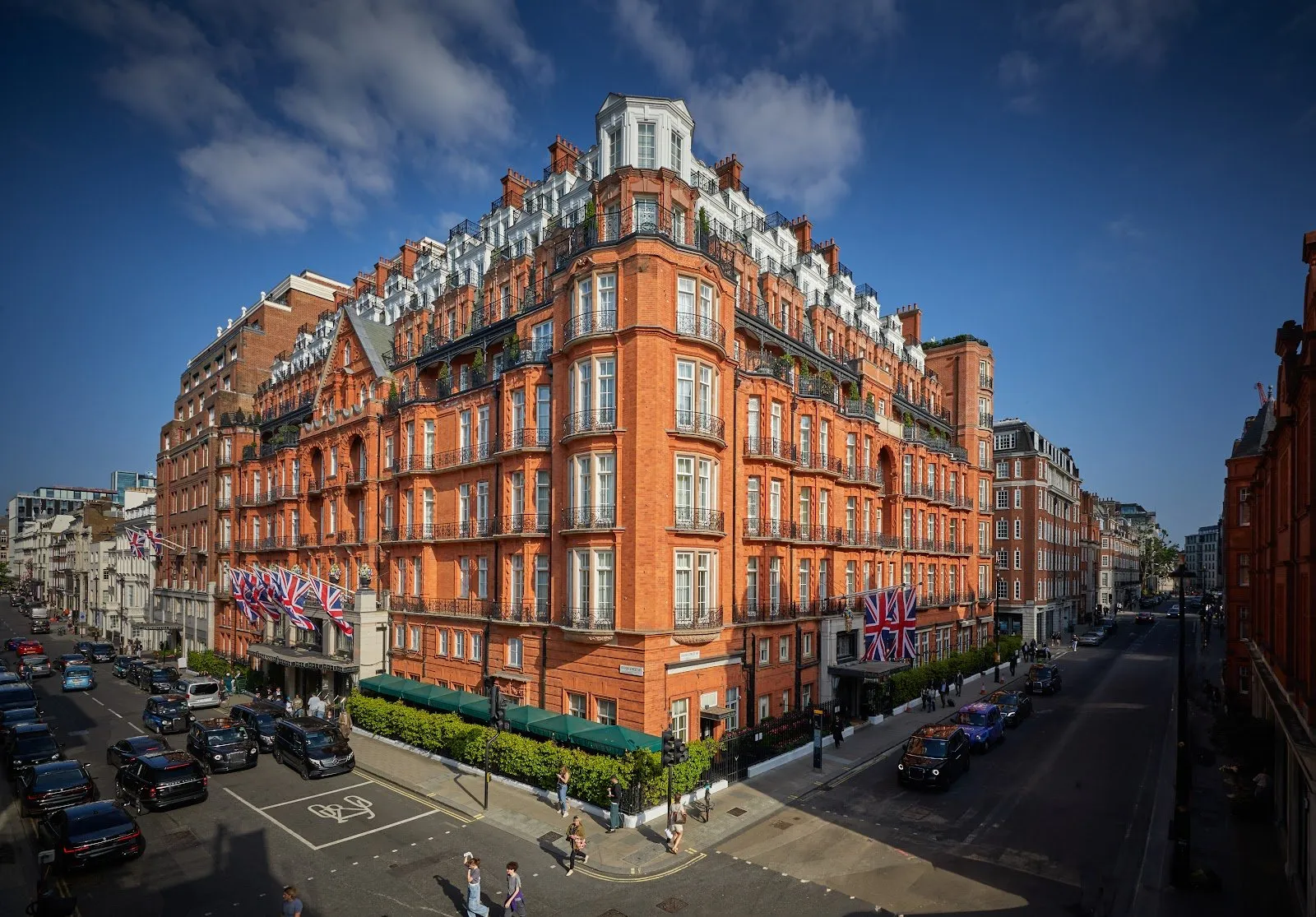 The red-brick and terracotta facade of Claridge's hotel on Brook Street in Mayfair under a blue sky