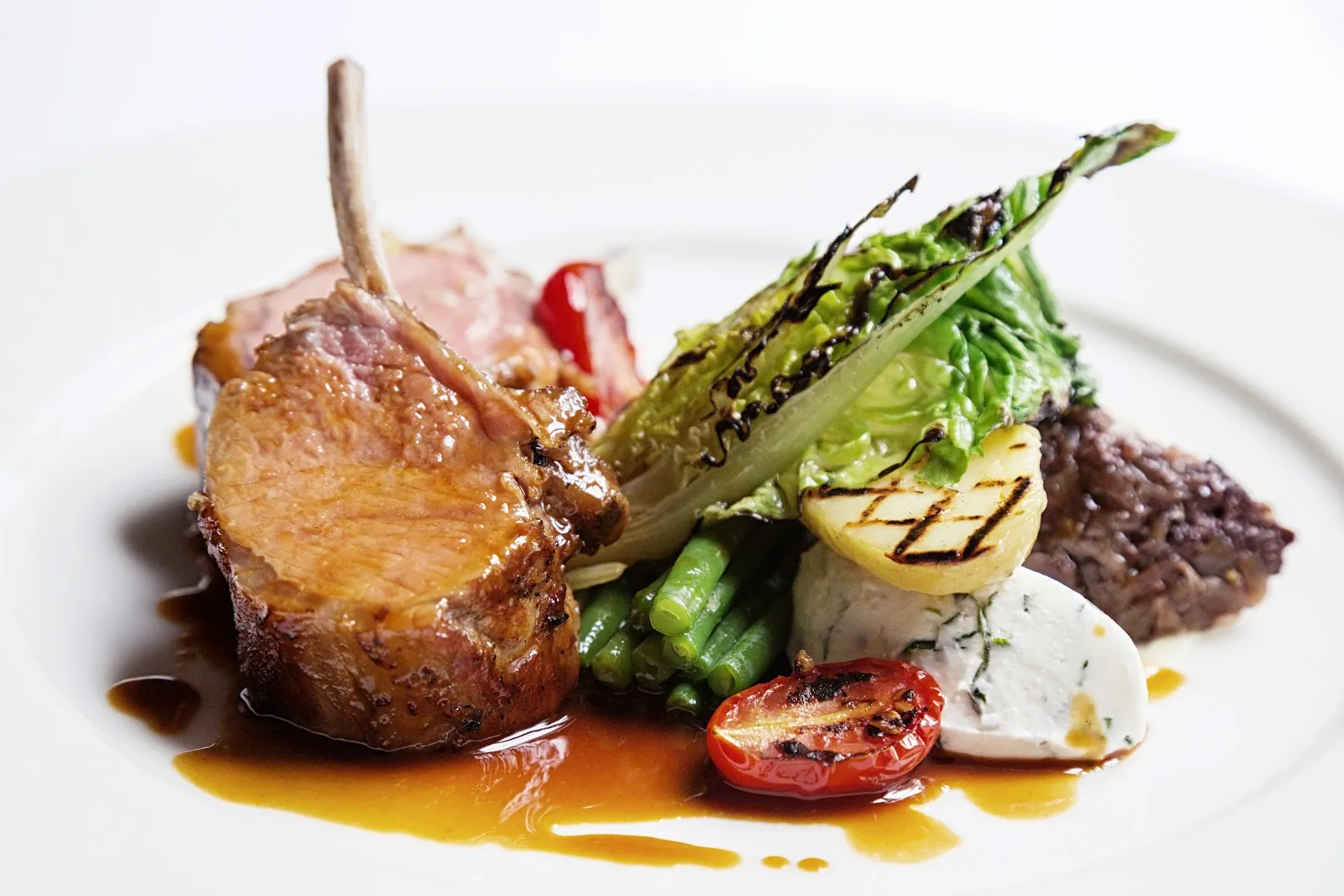 A rack of lamb with charred greens, tomato and a herbed sauce at Clos Maggiore