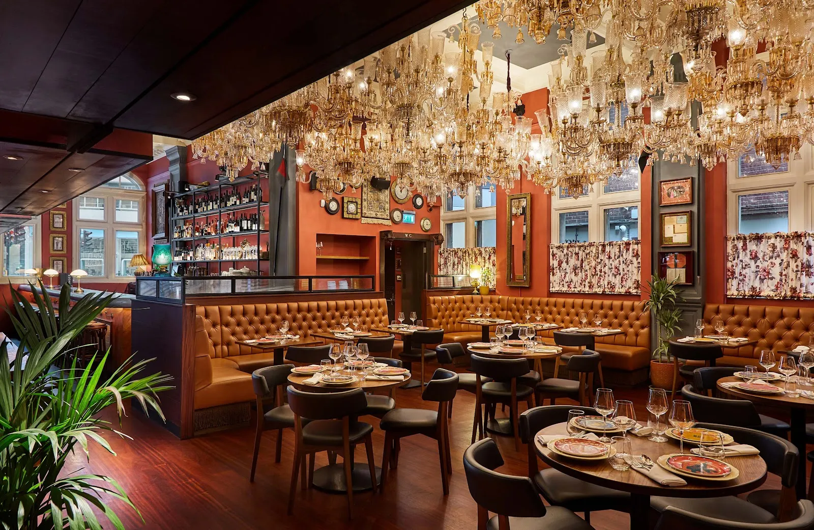 The dining room at Colonel Saab in the old Holborn Town Hall with antique crystal chandeliers and leather banquettes