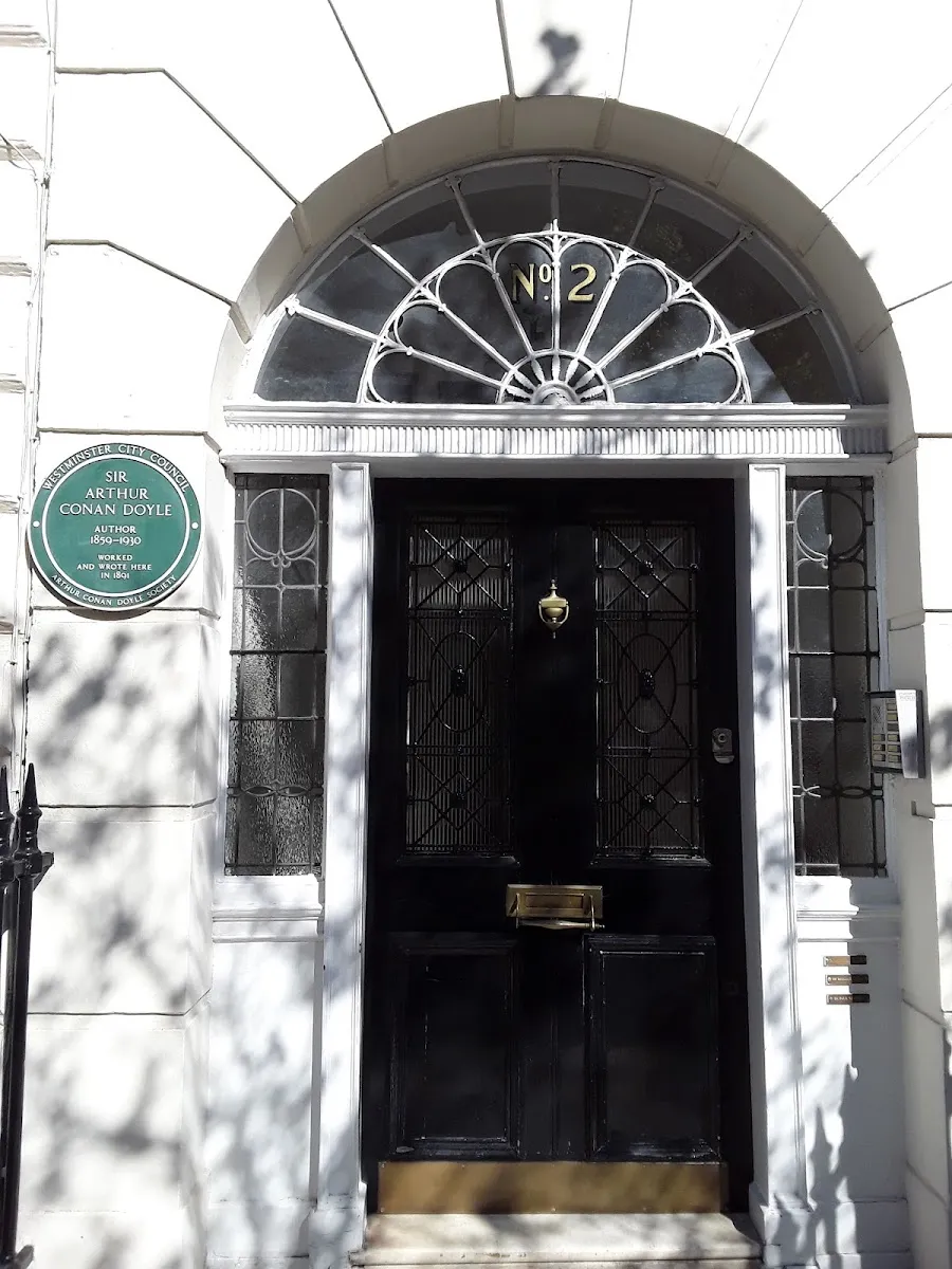 The black door of 2 Upper Wimpole Street, with the green Westminster City Council plaque to Sir Arthur Conan Doyle beside it