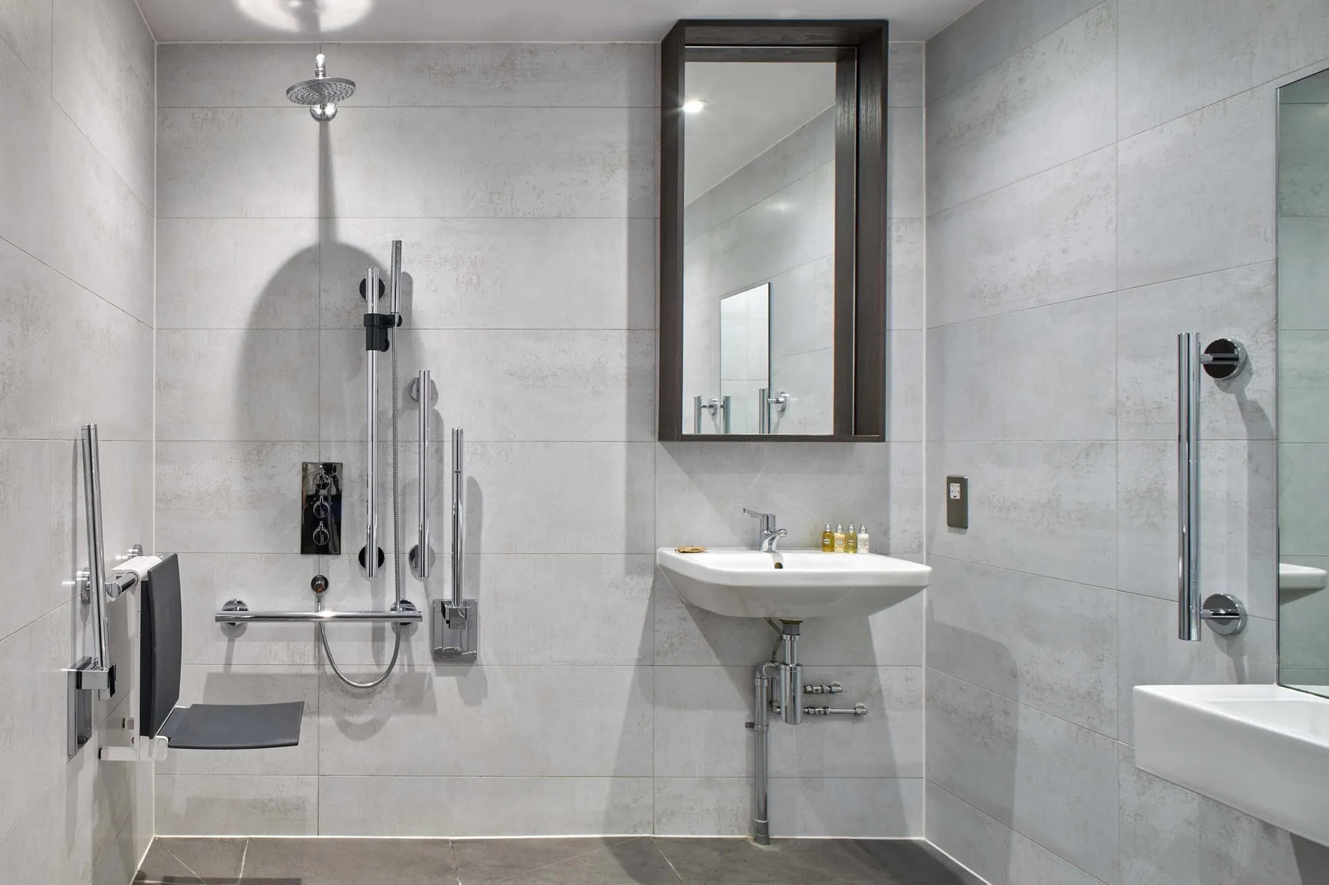 The bathroom at Cove Cannon Street, with stone-effect tile and a rainfall shower
