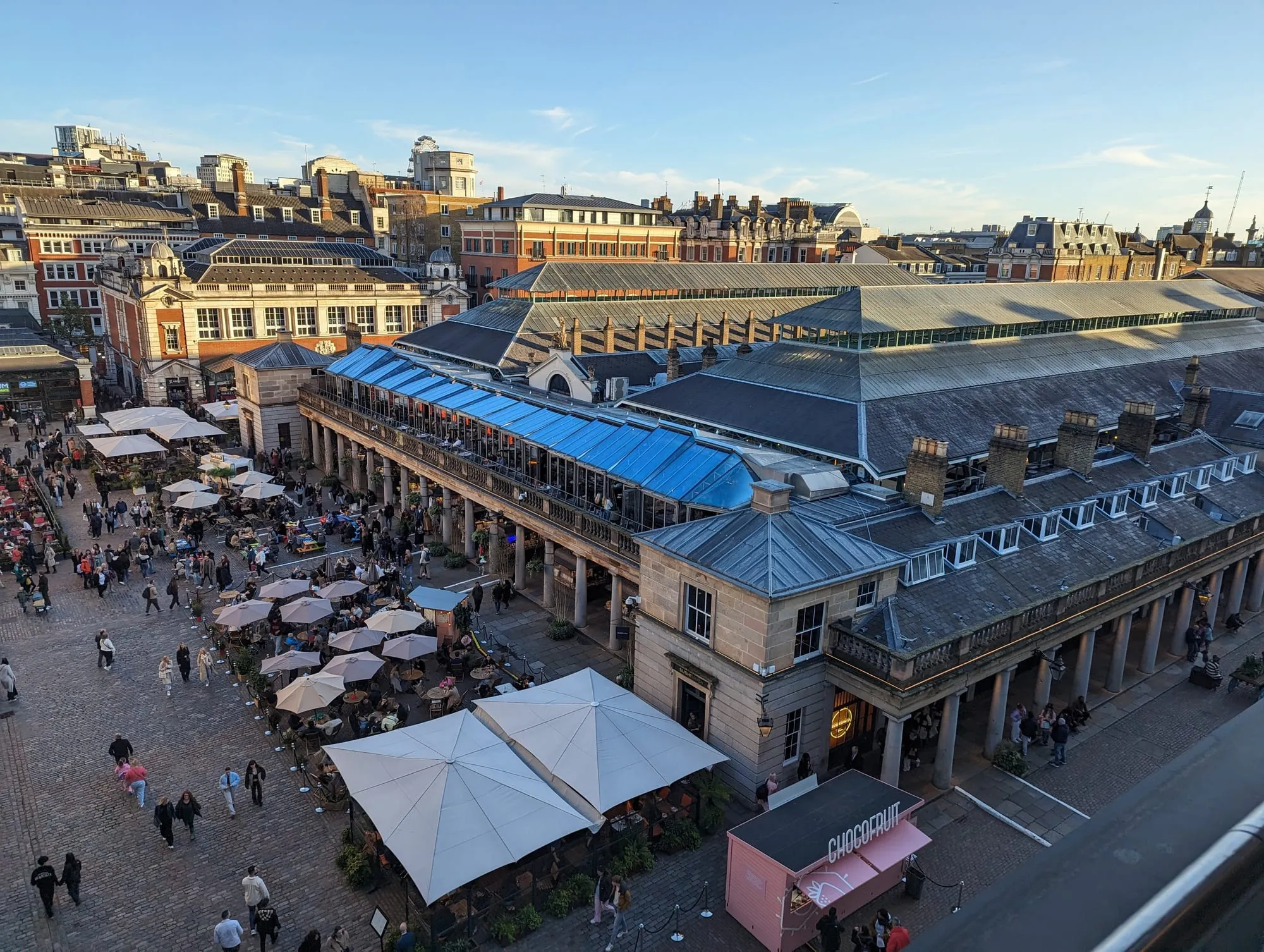 Covent Garden Piazza and the market halls seen from above, with parasols over the outdoor tables