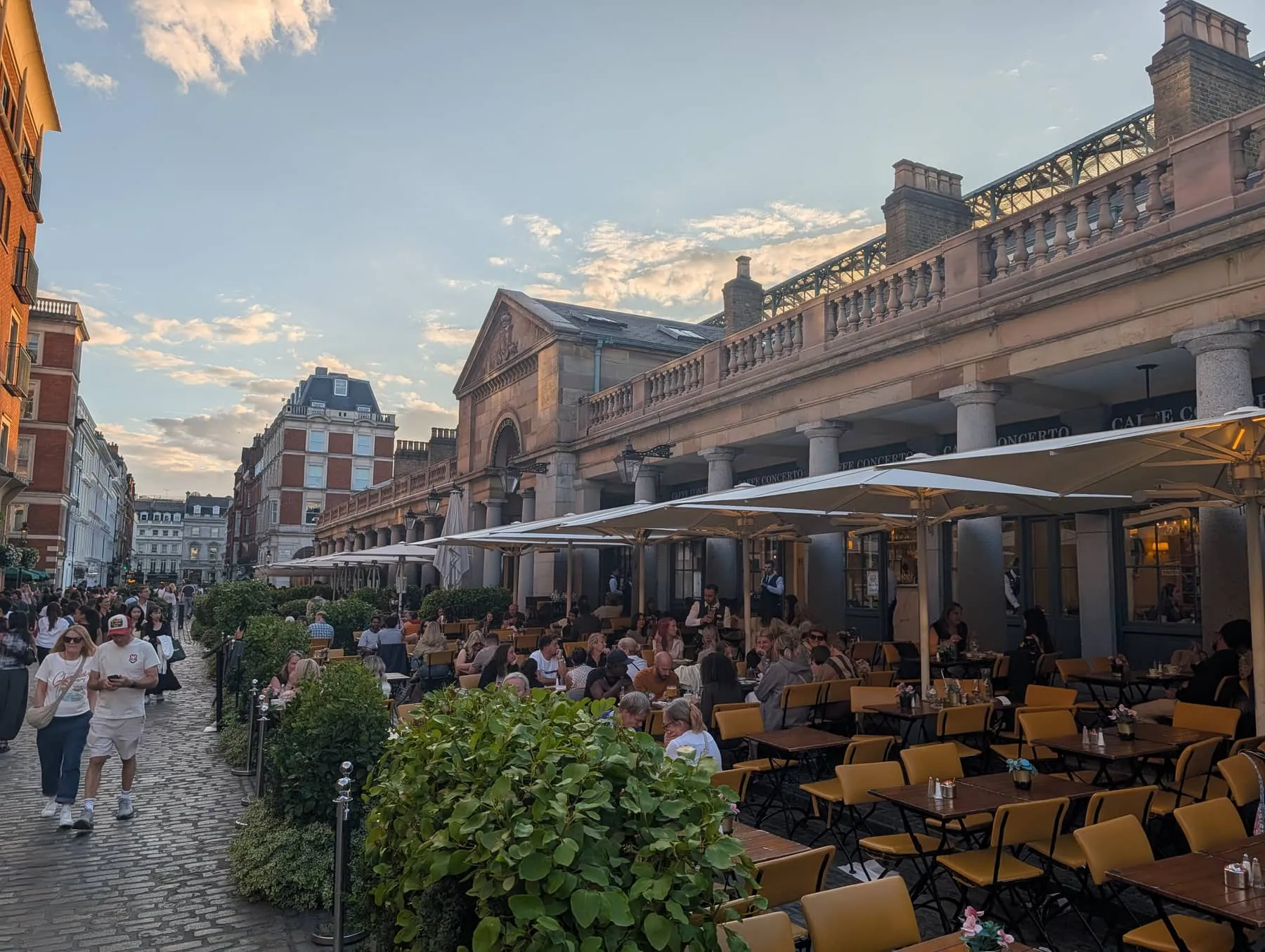 Outdoor restaurant terraces filling the cobbled Piazza at Covent Garden at dusk