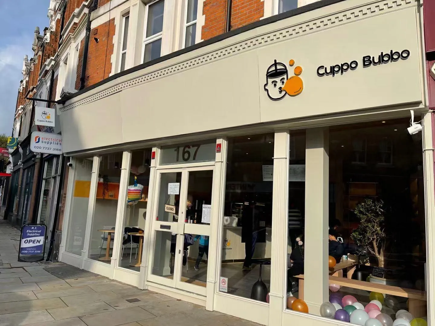 Cuppo Bubbo's long cream shopfront at 167 Herne Hill, with the logo above the windows and tables visible inside
