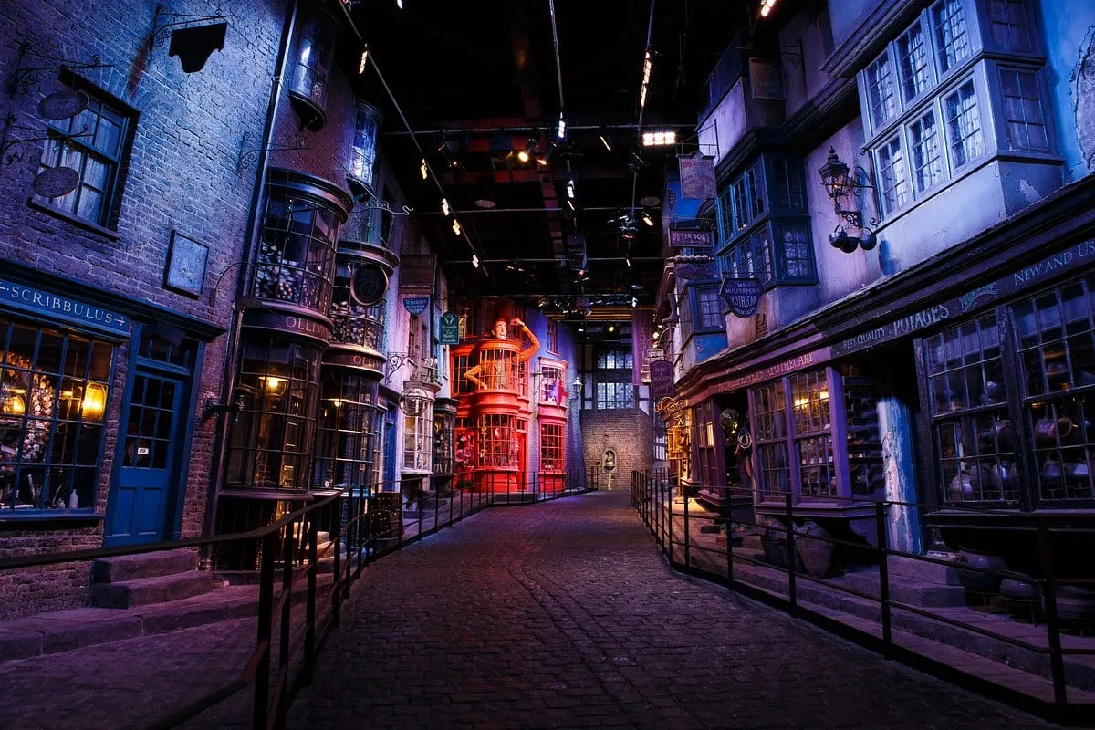Diagon Alley on the Studio Tour, the shopfronts lit purple and red down the length of the crooked street