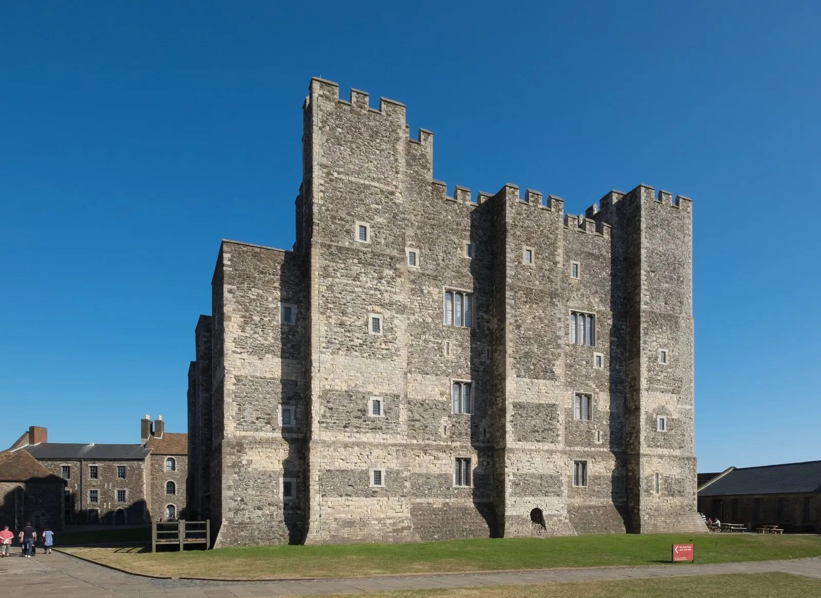 Dover Castle's Great Tower, a square stone keep with battlements, rising above the lawn under a clear sky
