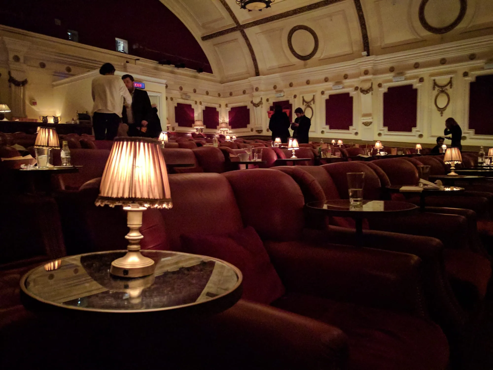 Rows of red leather armchairs with individual side-table lamps inside the Electric Portobello auditorium