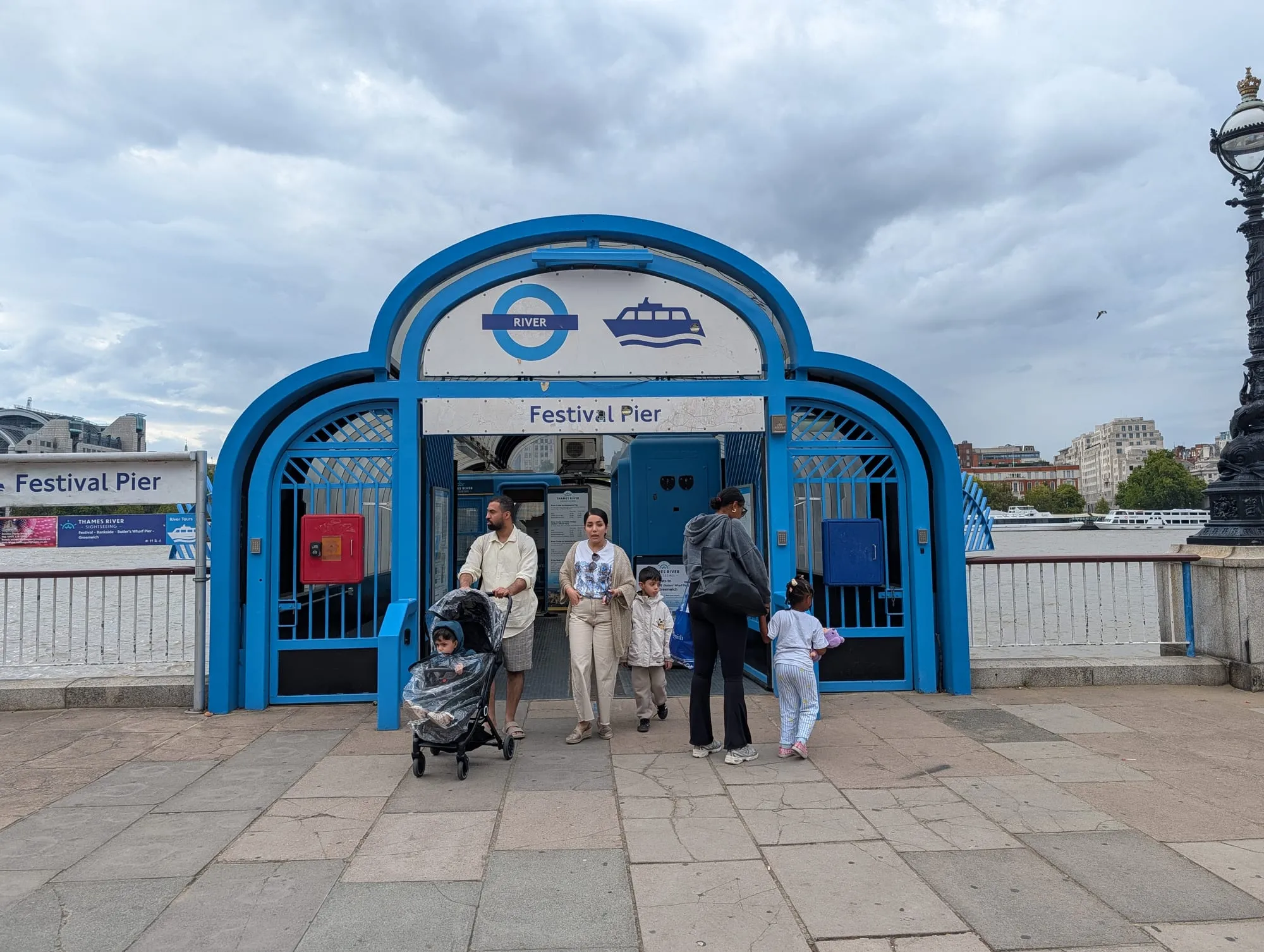 The blue-painted entrance arch of Festival Pier on the South Bank, signed for river boats and the Underground