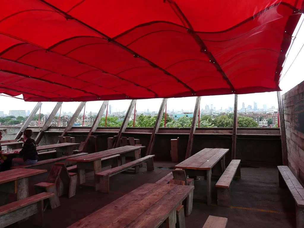 The red canopy of Frank's Cafe on a Peckham car park roof, with the London skyline beyond