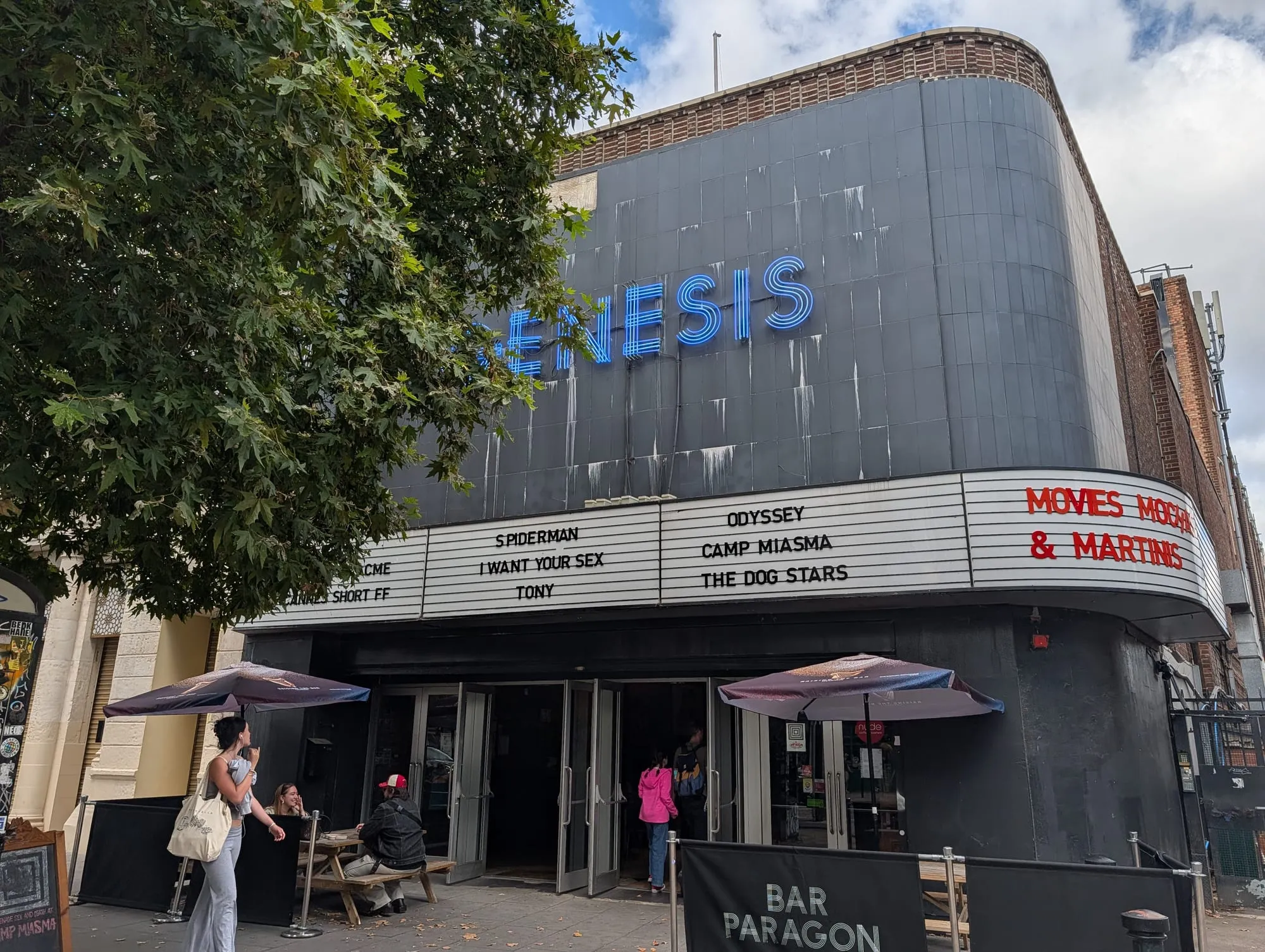 The curved black frontage of the Genesis Cinema in Mile End, its listings board showing the week's films