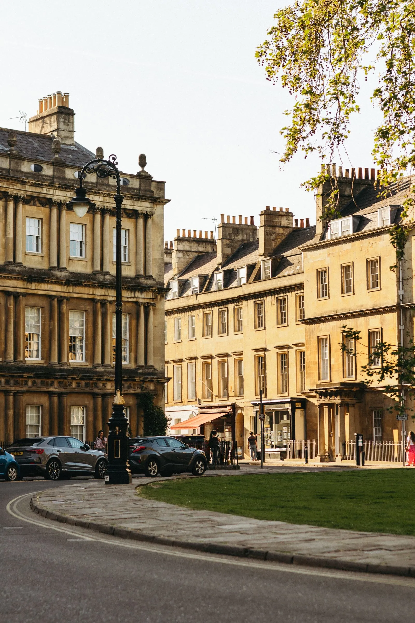 A Bath street of honey-coloured Georgian terraces with shopfronts at street level