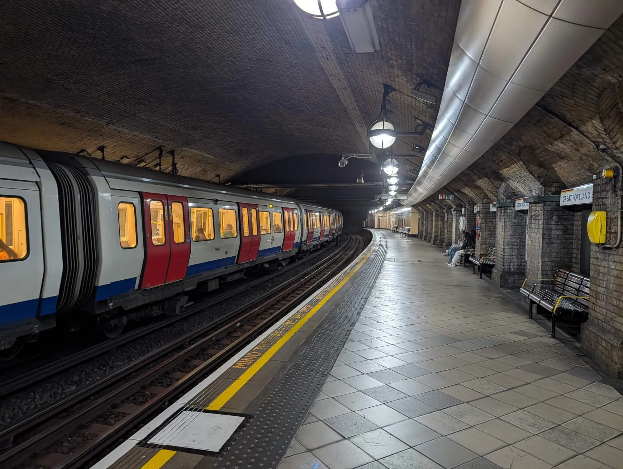 A sub-surface line train waiting at the tiled platform at Great Portland Street station