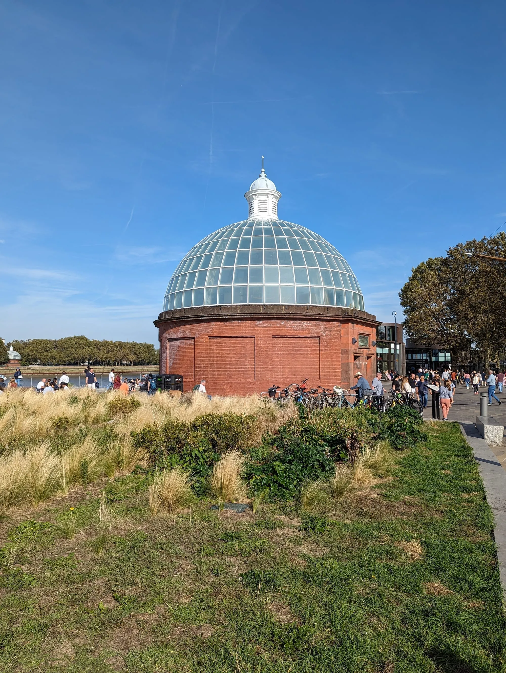 The red brick and glass domed rotunda entrance to the Greenwich Foot Tunnel beside the Thames