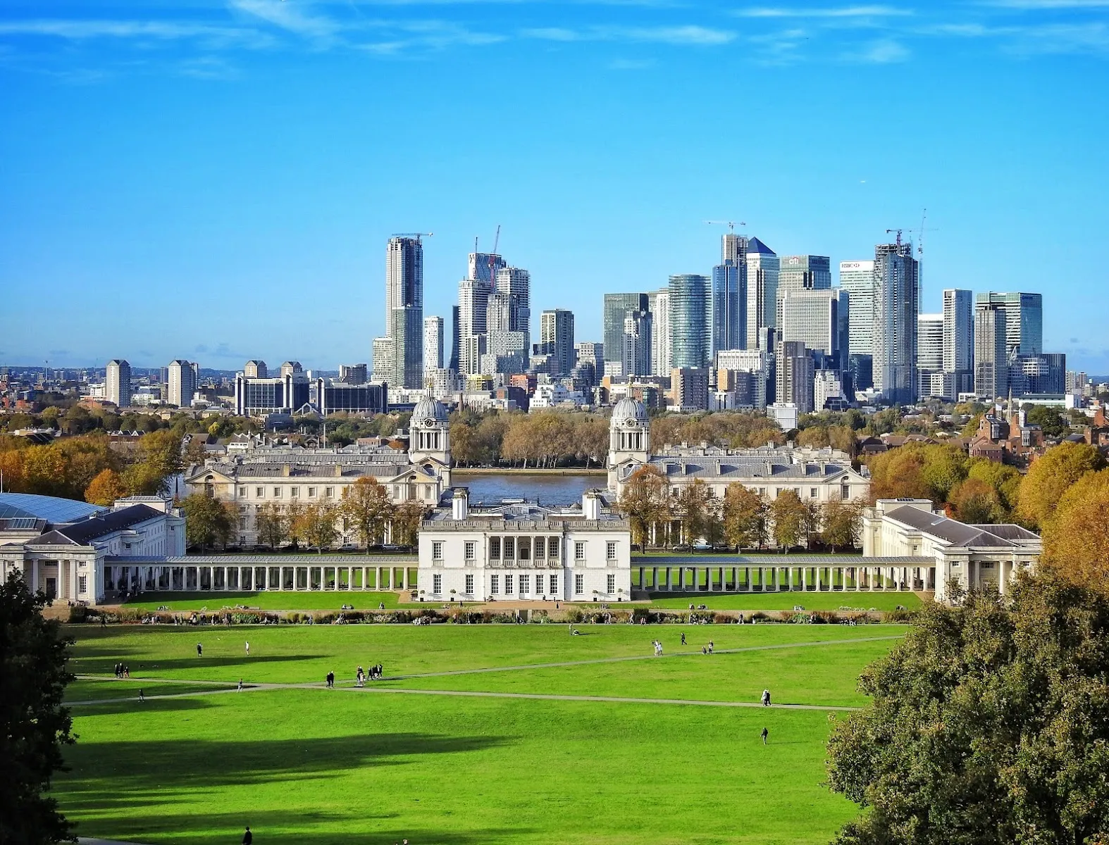 The view down Greenwich Park's hill towards Queen's House and the Old Royal Naval College, avenues of trees in autumn colour on either side