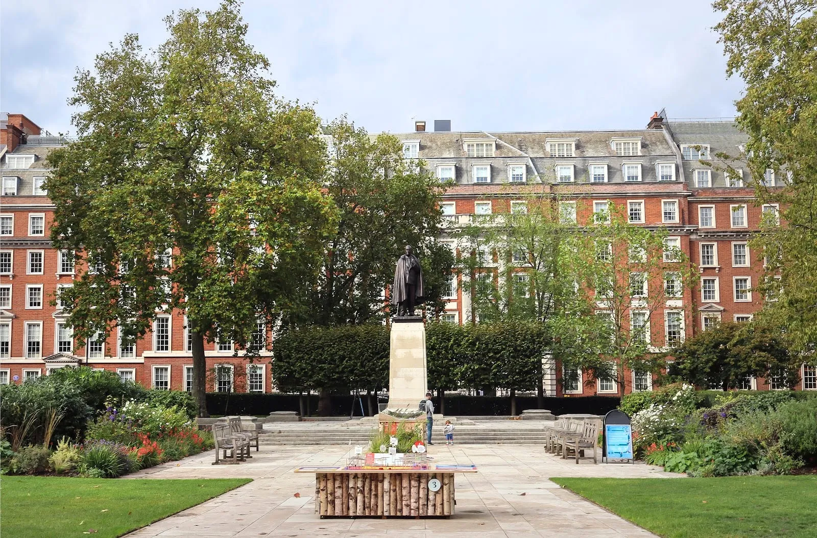 The Franklin D. Roosevelt memorial statue among trees and planting in the redesigned Grosvenor Square