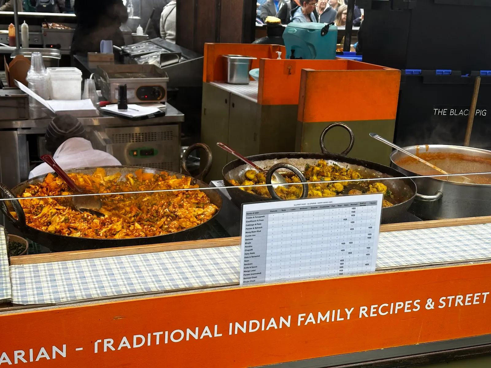 Large karahi pans of spiced vegetable curries and simmering dhal at Gujarati Rasoi in Borough Market