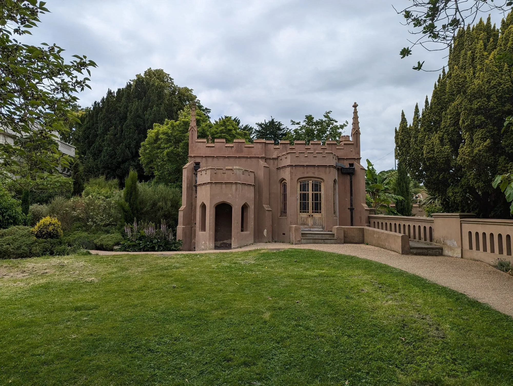 The small castellated Gothic Ruins folly on a lawn at Gunnersbury Park
