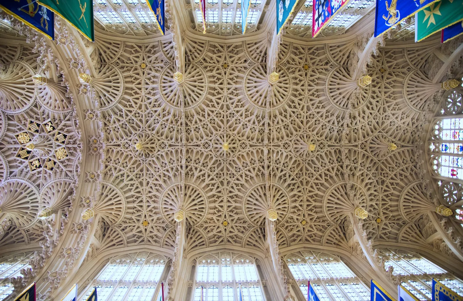 Intricate 16th-century fan-vaulted stone ceiling with decorative pendants and heraldic banners in the Henry VII Lady Chapel