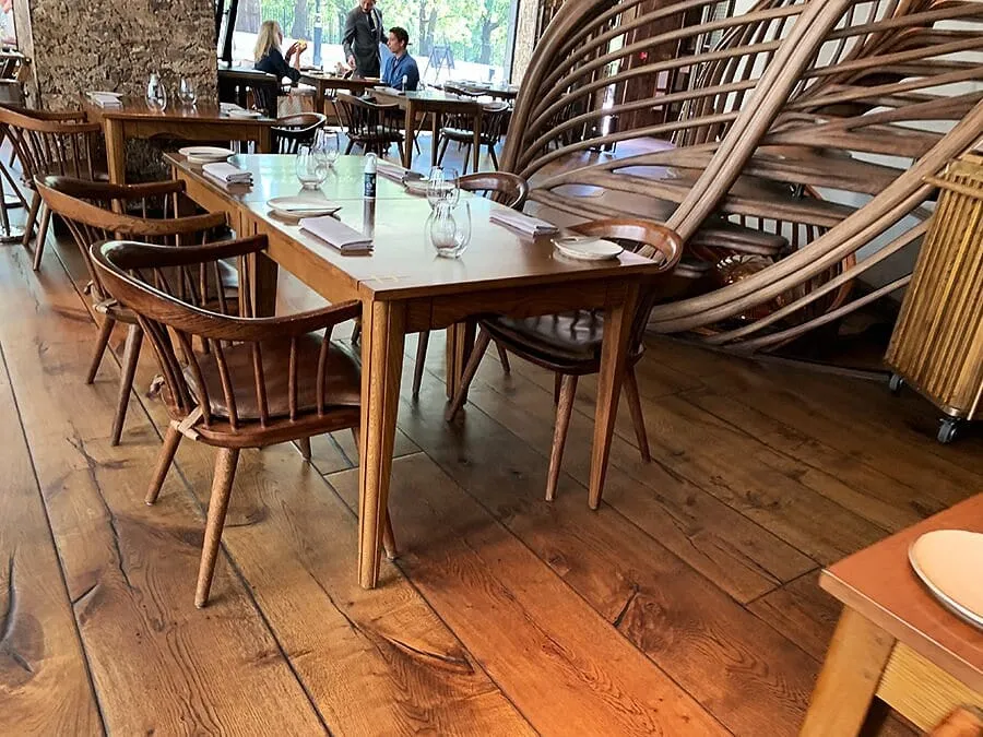 Hide's dining room in pale wood, with its curved timber staircase rising behind the tables