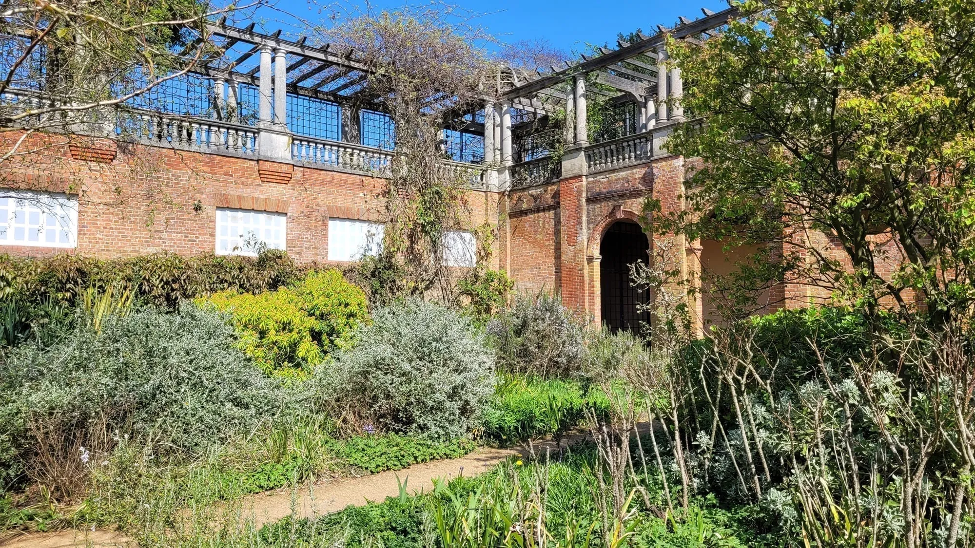 The brick and stone Hill Garden Pergola on Hampstead Heath, with planting along its raised walkway