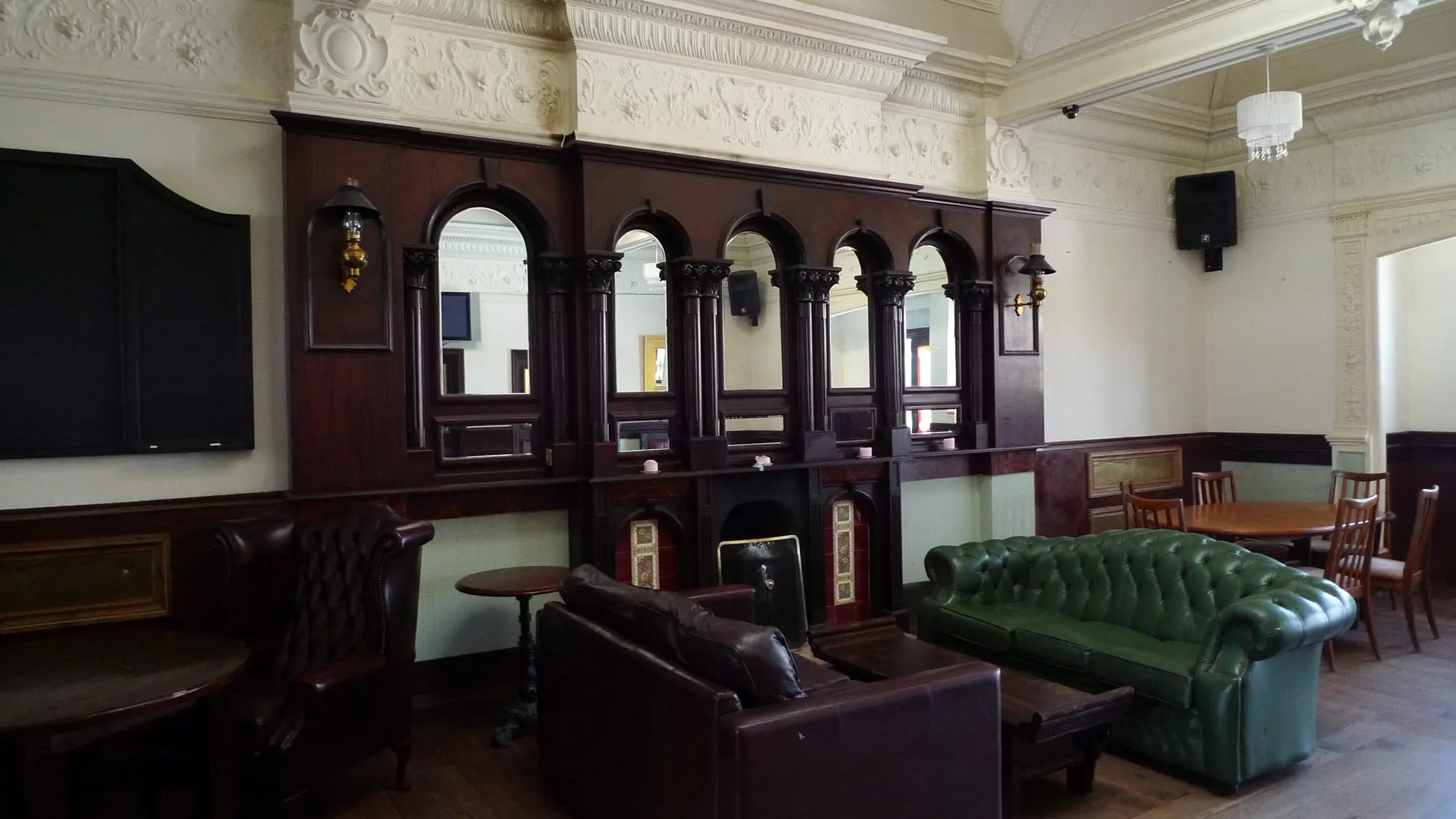 The ornate Victorian interior of a London pub, with etched glass and dark panelling