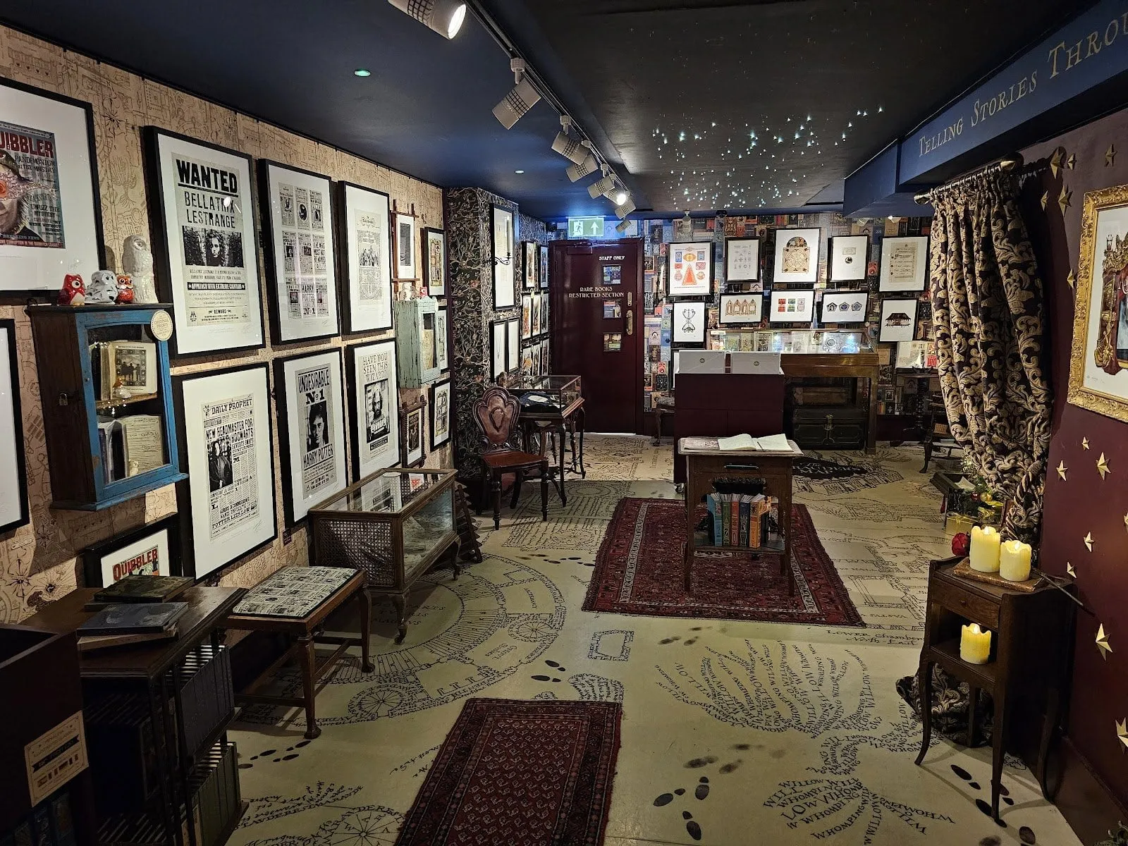 Inside House of MinaLima: framed Wanted posters for Bellatrix Lestrange and Harry Potter, Daily Prophet front pages and Quibbler covers on the walls, glass display cases, and a floor printed like the Marauder's Map