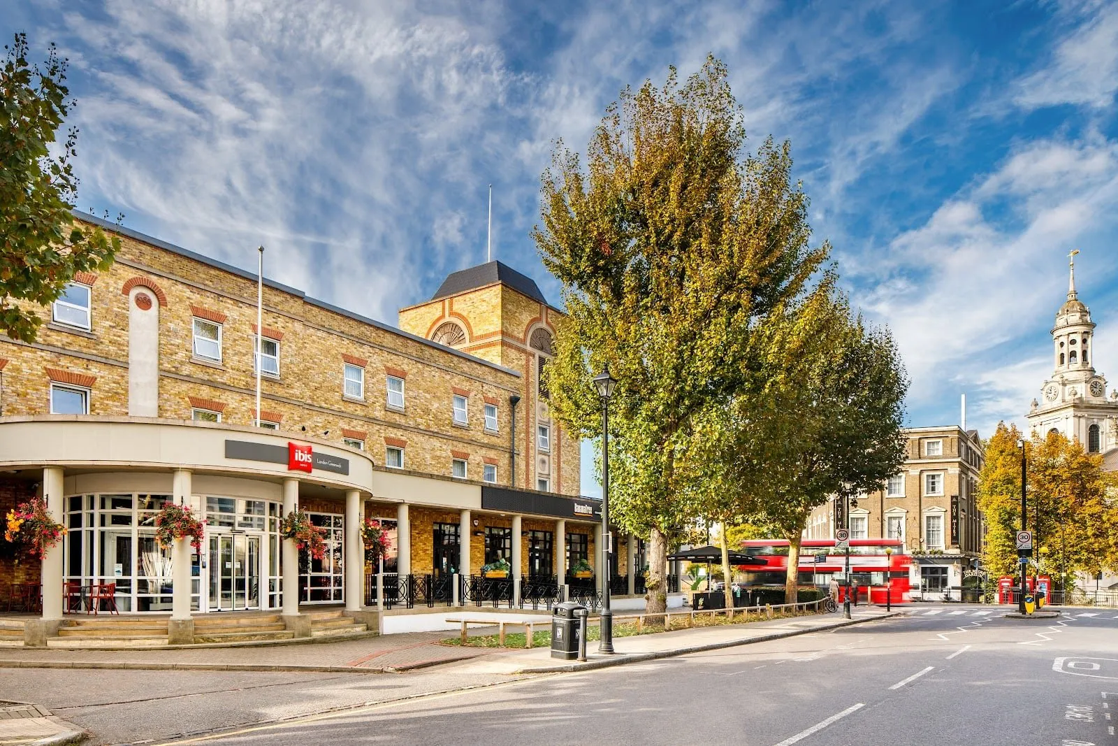 The front of ibis London Greenwich on Stockwell Street, with the tower of St Alfege Church to the right